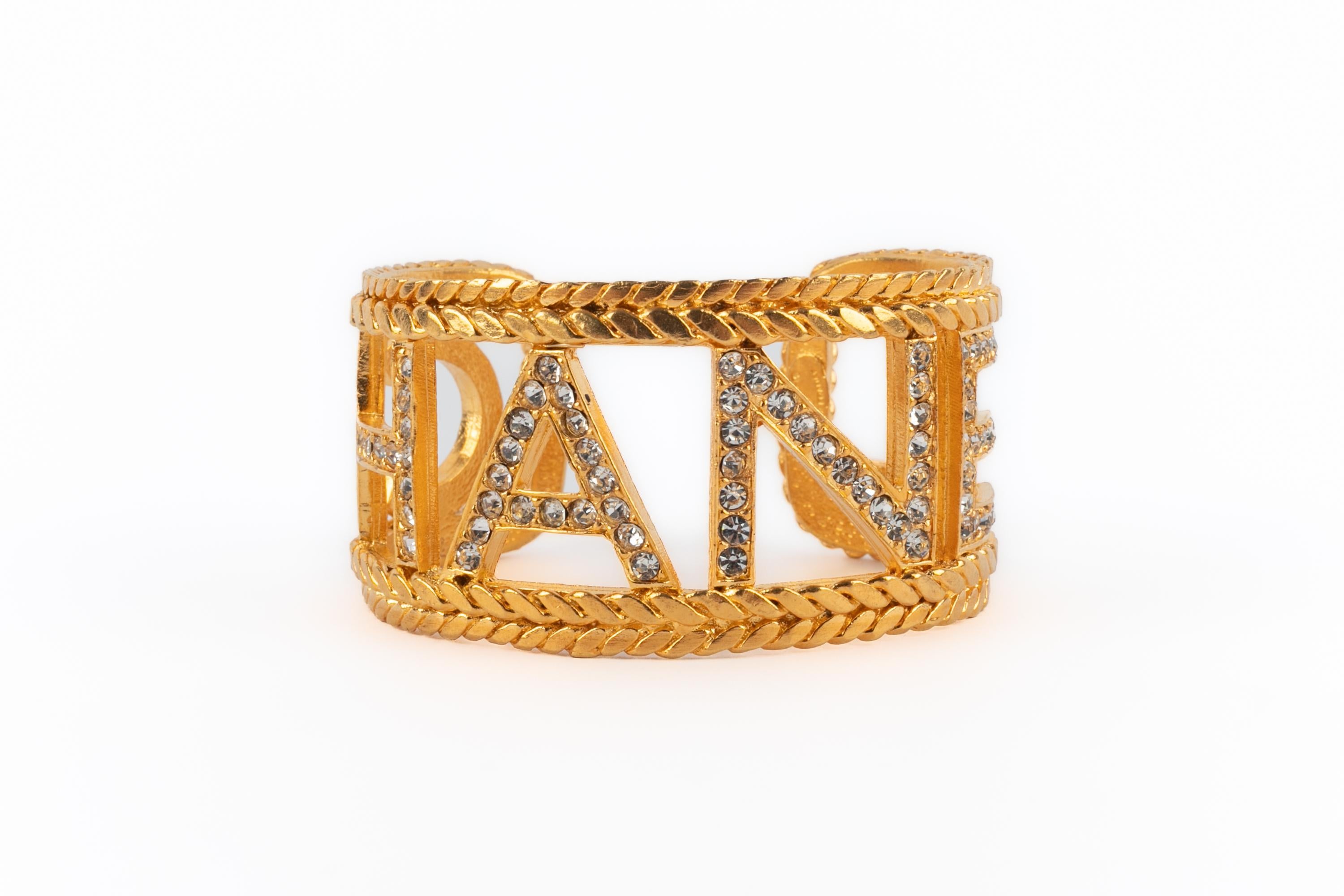 CHANEL - (Made in France) Pulsera calada de metal dorado con brillantes blancos.

Estado:
Muy buen estado

Dimensiones:
Circunferencia: 14 cm - Abertura: 2 cm - Anchura: 3 cm

SKU:BRAB141