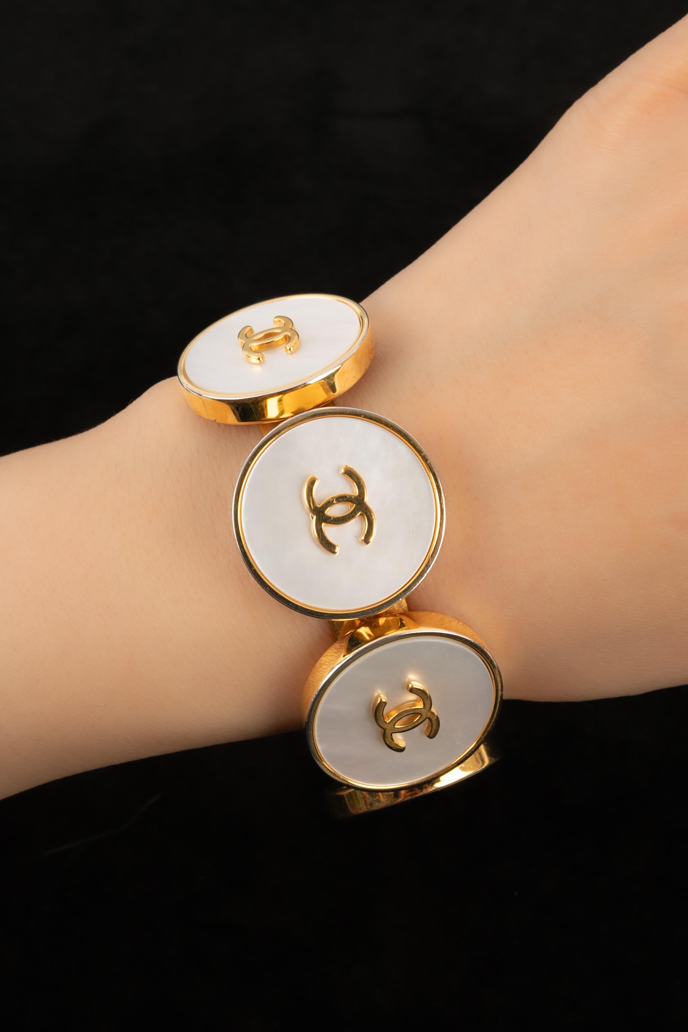 CHANEL - (Fabriqué en France) Bracelet en métal doré avec nacre. Collectional automne-hiver 1995.

Condit :
Très bon état.

Dimensions :
Longueur : 14,5 cm - Ouverture : 2,5 cm

BRAB37