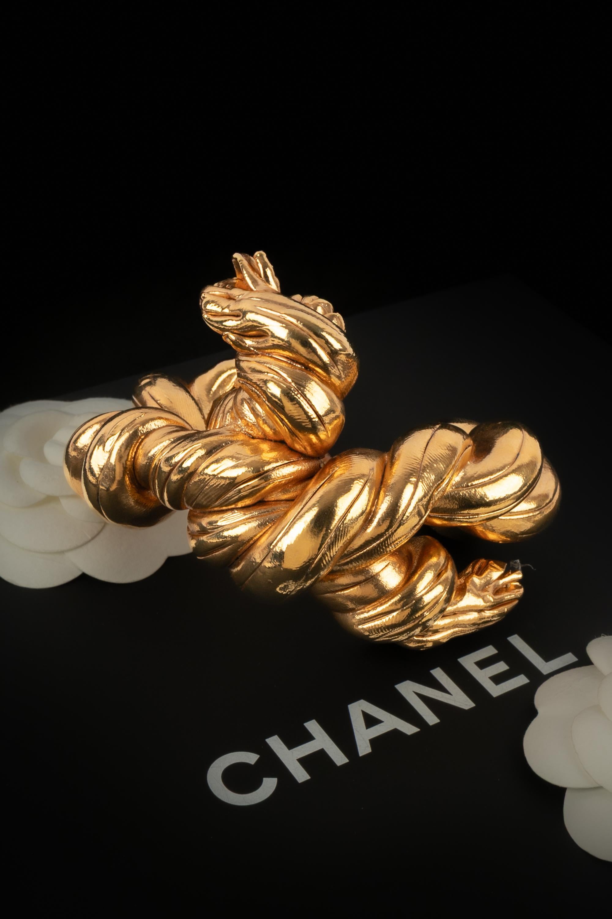 CHANEL - (Fabriqué en France) Bracelet manchette en métal doré. Collectional printemps-�été 1990 sous la direction artistique de Karl Lagerfeld.

Condit :
Très bon état.

Dimensions :
Circonférence : 15 cm - Ouverture : 3 cm - Largeur : 5,2