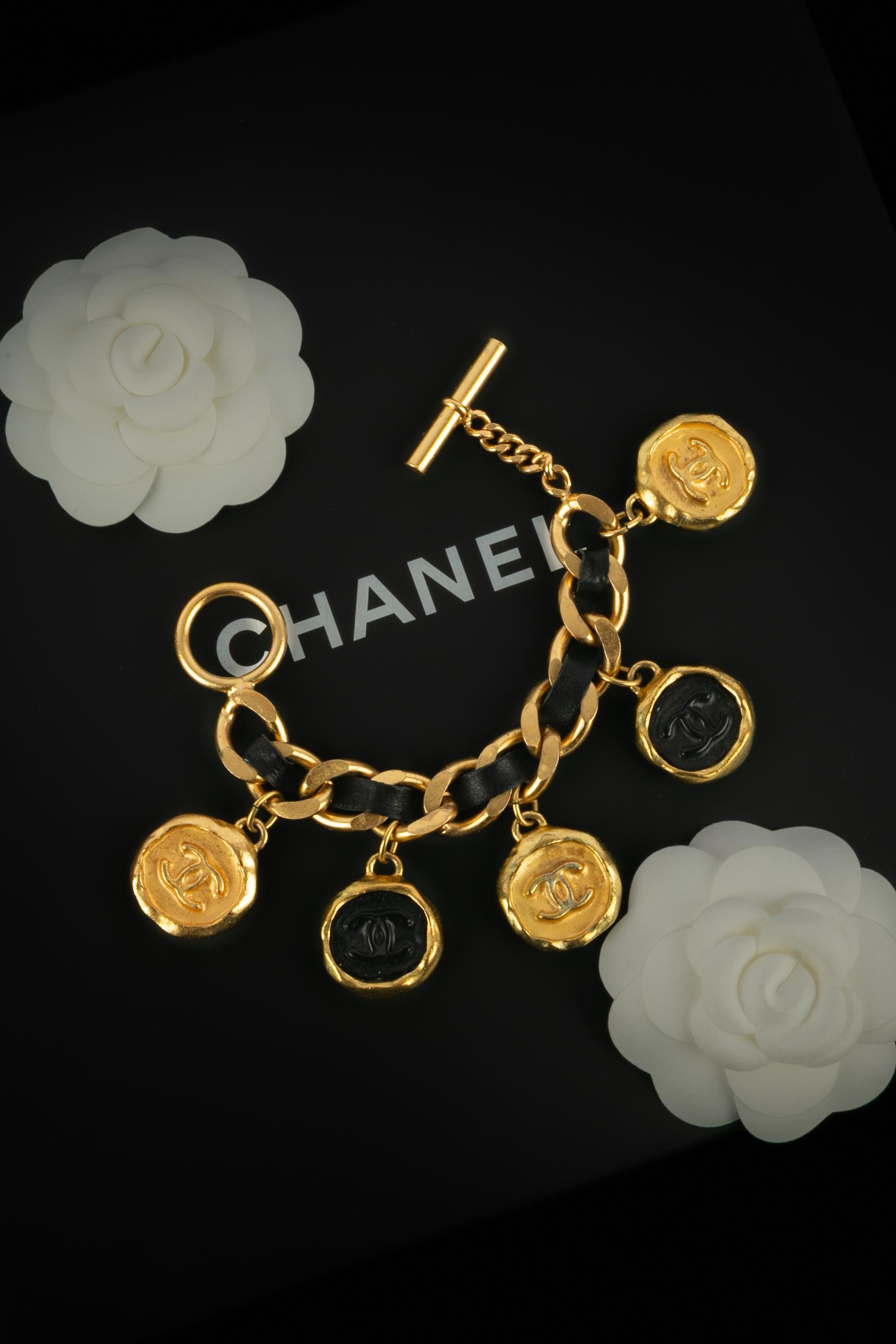 CHANEL - (Fabriqué en France) Bracelet en métal doré avec cuir noir et breloques cc. Collectional printemps-été 1995 sous la direction artistique de Karl Lagerfeld.

Condit :
Très bon état.

Dimensions :
Longueur : 19 cm

SKU:BRAB19