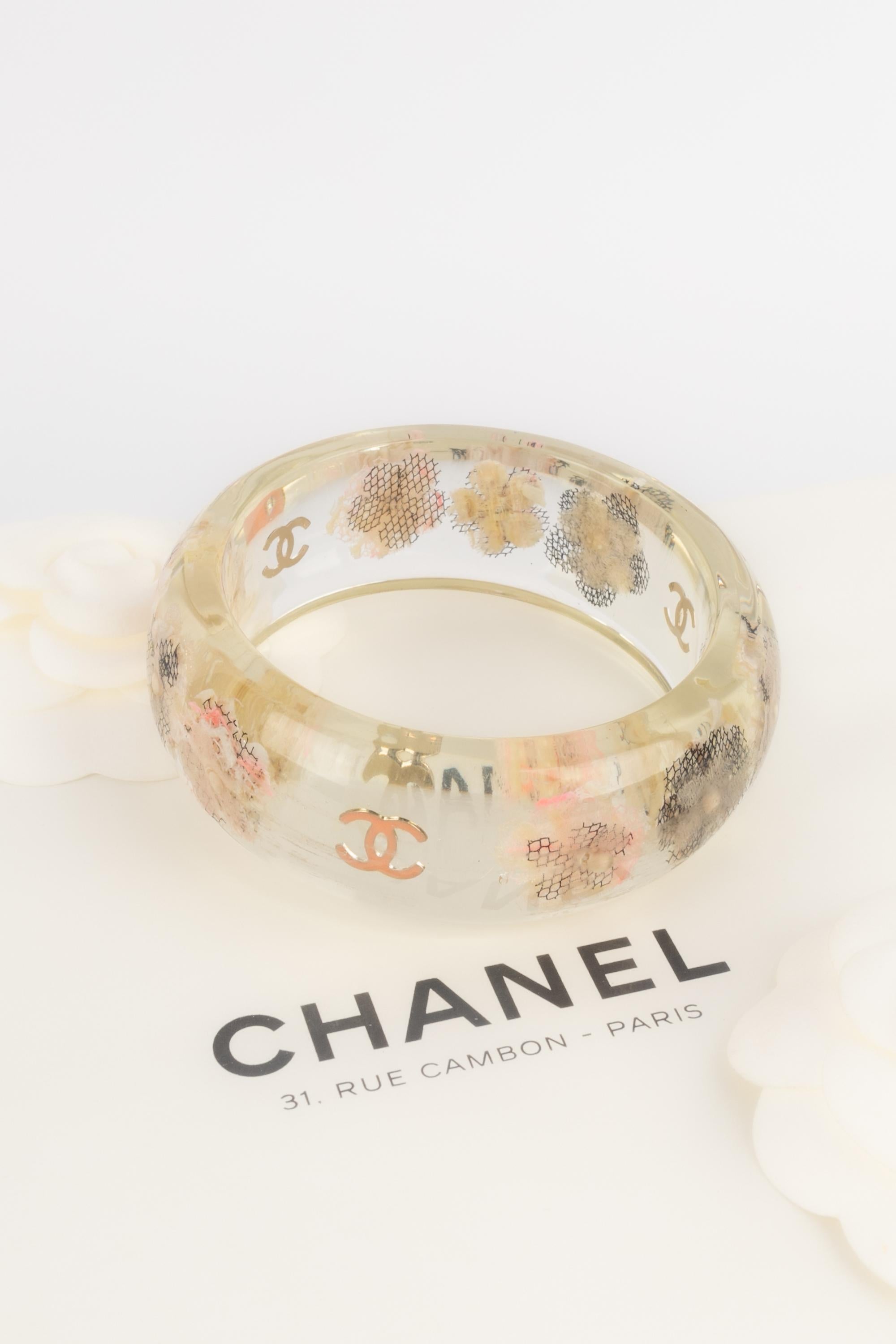 CHANEL - (Made in France) Lucite rigid bracelet inlaid with flowers and cc logos. Not signed fashion show jewelry from private sales.

Condition:
Very good condition

Dimensions:
Circumference: 20 cm

SKU:BRAB119