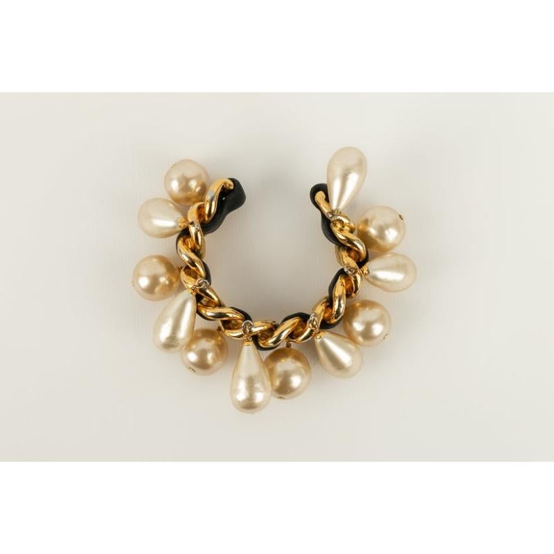 Chanel - (Made in France) Bracelet in golden metal interlaced with black leather. It is ornamented with costume pearly drops. 2cc3 Collection. To be noted, few traces on the beads.

Additional information:
Condition: Very good condition
Dimensions: