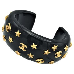 Chanel open bracelet, molded black plastic signed 95 CC P with gold stars and CC