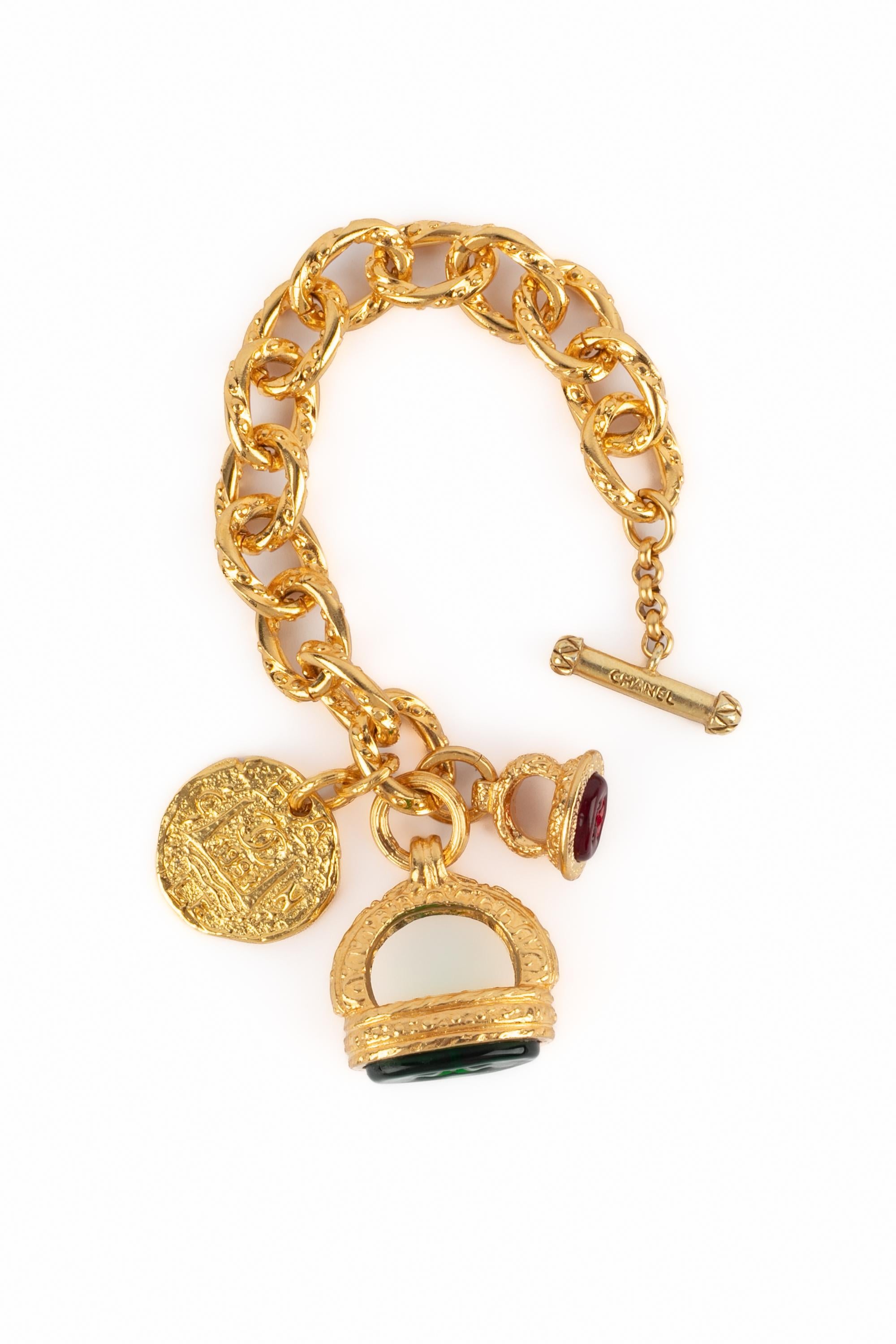 CHANEL - (Made in France) Golden metal chain bracelet with charms set with green and red glass paste. 1993 Fall-Winter Collection under the artistic direction of Karl Lagerfeld.

Condition:
Very good condition

Dimensions:
Length: 20 cm

SKU:BRAB80