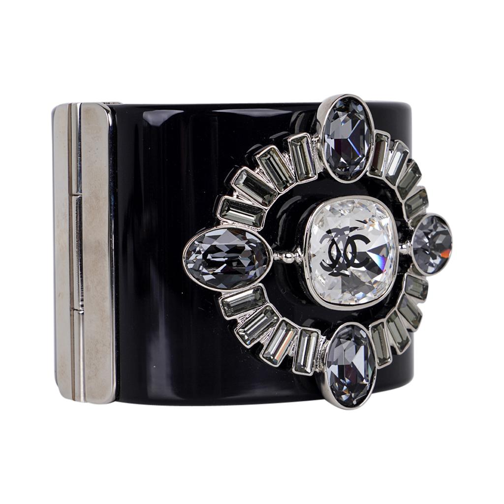 Mightychic offers a Chanel jeweled cuff bracelet.
The cuff is Black Resin with silver trim.
Rich jeweled centerpiece with smoky Strass Crystals.
A stunning white Strass Crystal with black CC.
A breathtaking piece.
This fabulous bold statement cuff