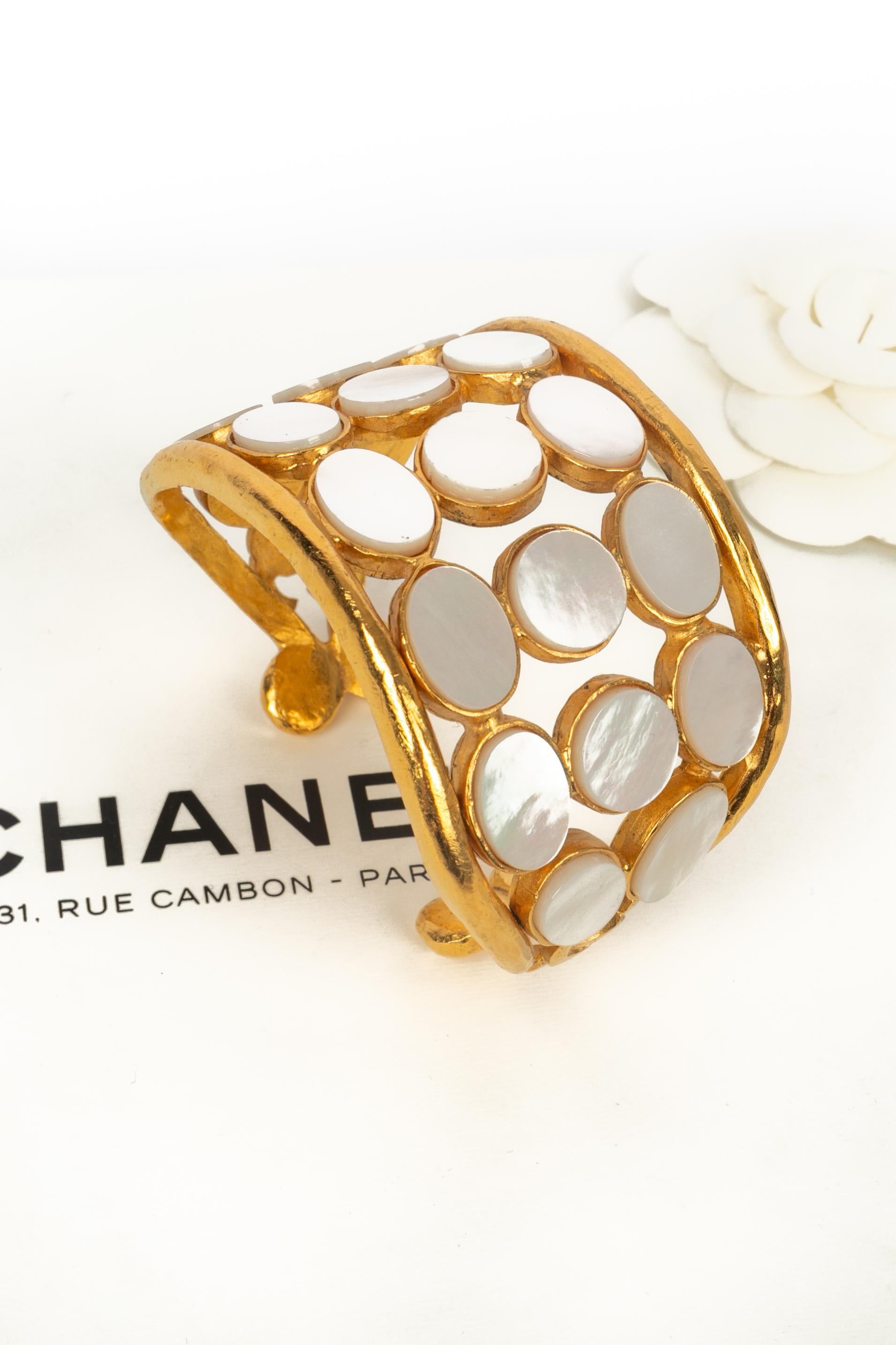 CHANEL - (Made in France) Pulsera calada de metal dorado con material nacarado. Colección Otoño-Invierno 1995 bajo la dirección artística de Karl Lagerfeld.

Estado:
Muy buen estado

Dimensiones:
Longitud: 15 cm - Abertura: 3 cm

SKU:BRAB20