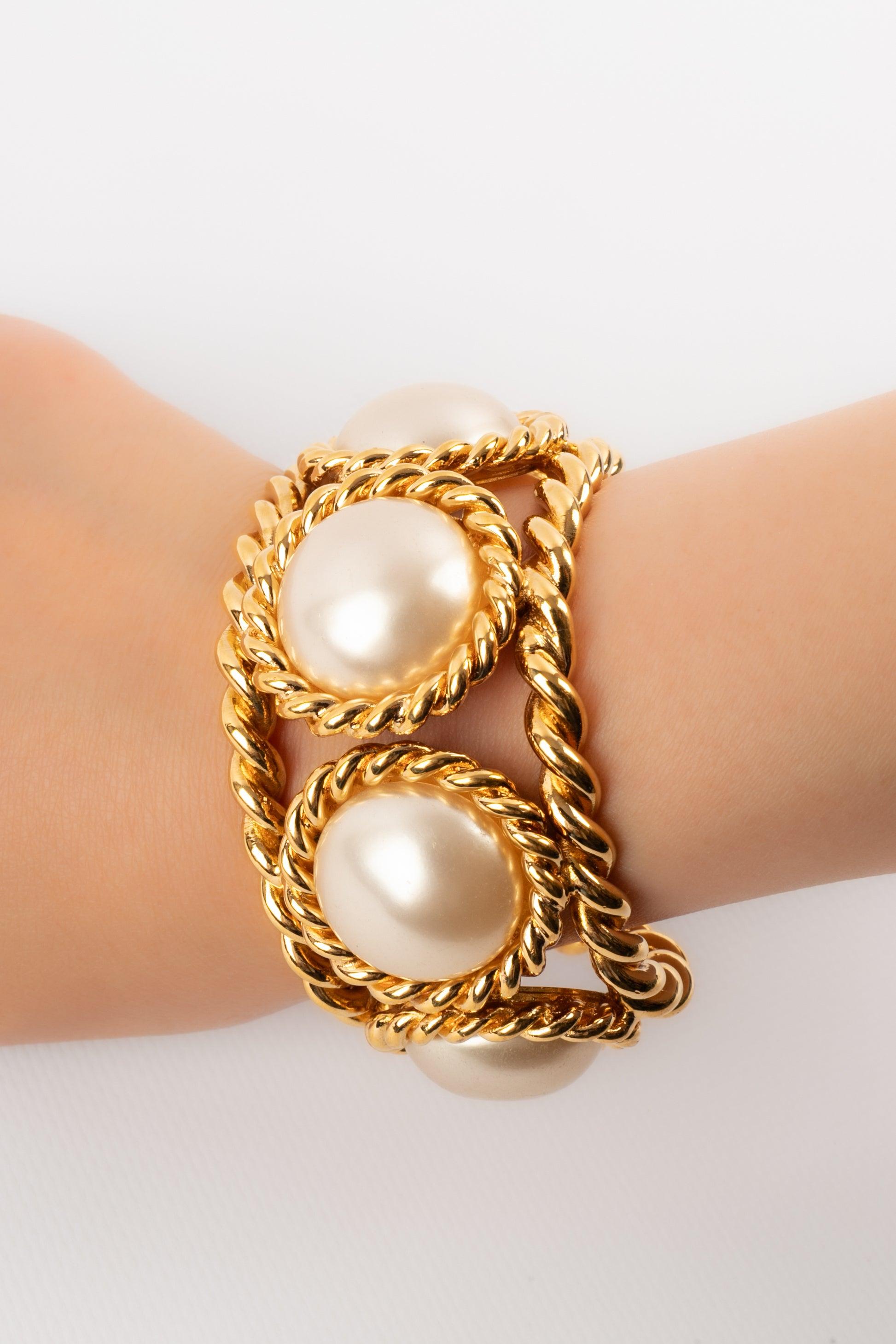 Chanel - (Made in France) Pulsera calada de metal dorado con cabujones nacarados. Colección 2008.

Más información: 
Estado: Muy buen estado
Dimensiones: Longitud: 15 cm - Abertura: 3 cm

Referencia del vendedor: BRAB27