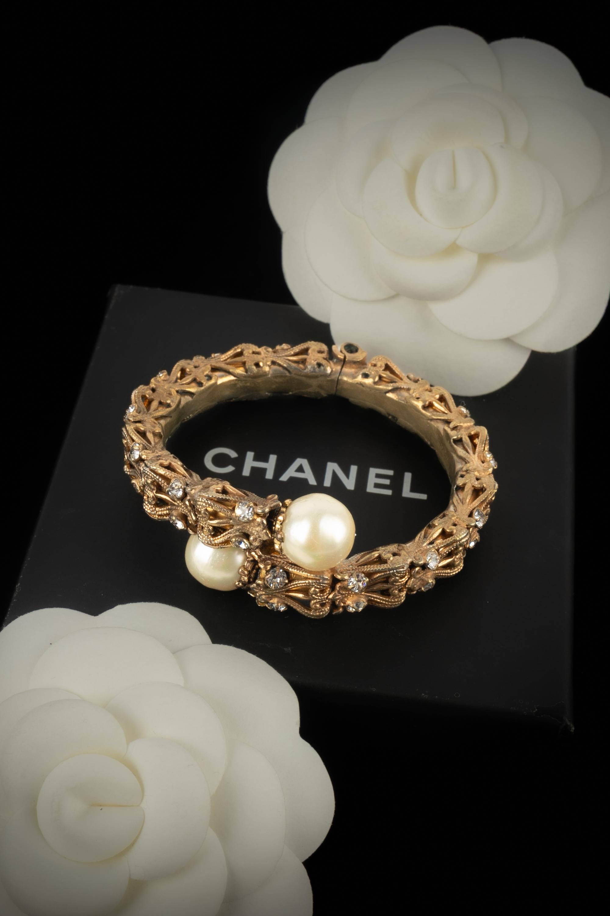 CHANEL - Openwork golden metal bracelet decorated with rhinestones and costume pearls. Jewelry from the Coco era circa 1950.

Condition:
Good condition

Dimensions:
Wrist circumference: 14 cm

SKU:BRAB39