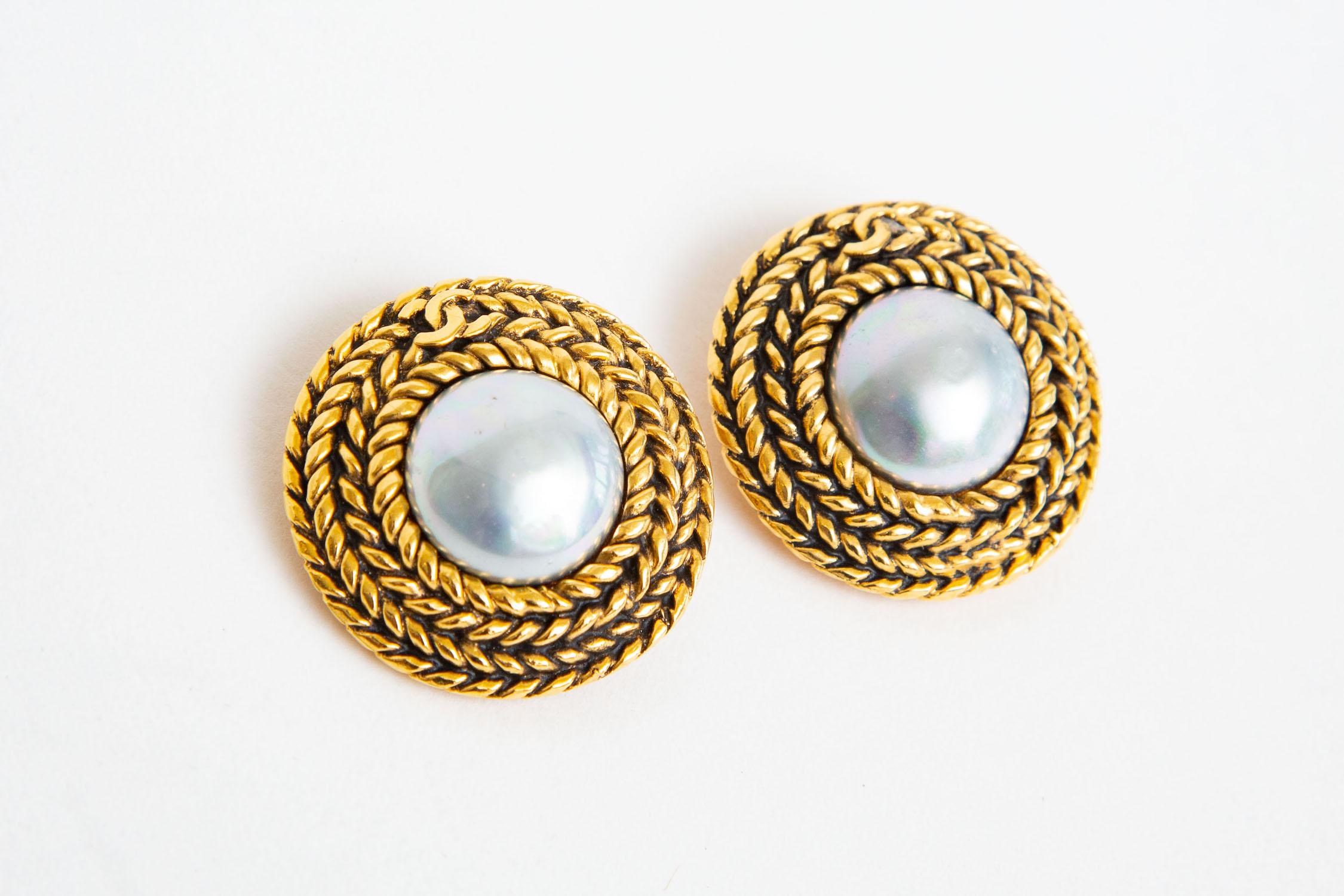 These large and 80's Chanel braided gilt metal and center baroque gray faux pearl have the small iconic CC's on the top that are interwoven. They are button clip on earrings and marked. They are 1.5
