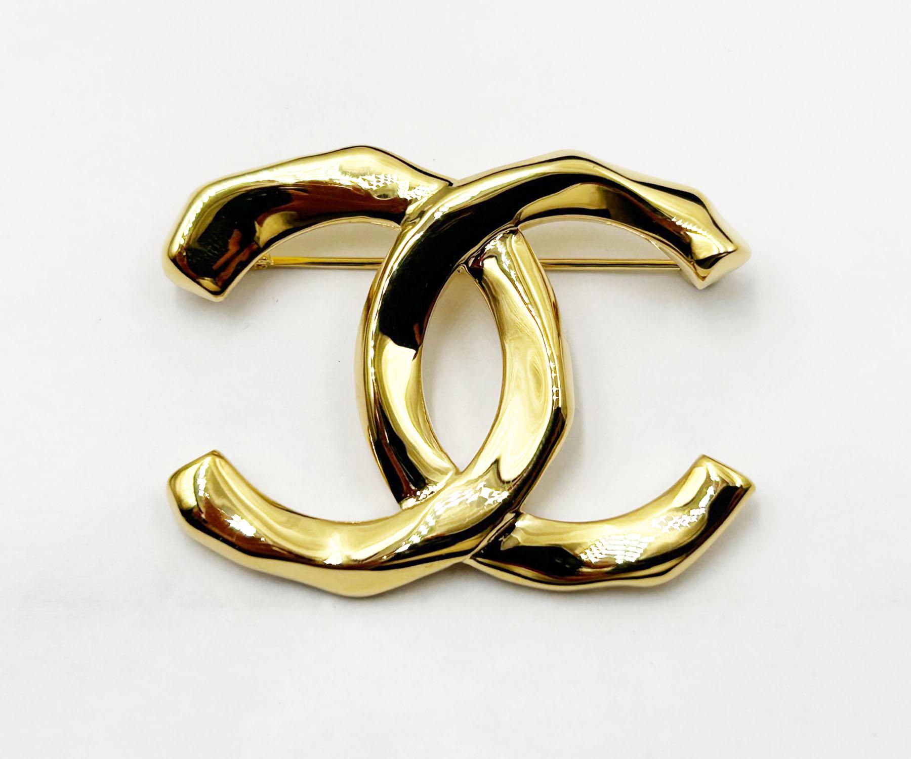 Chanel Brand New Gold Bended CC Brooch 

*Marked 23
*Made in France
*Comes with the original box, pouch, booklet, camellia and ribbon
*Brand New

- It is approximately 0.75' x1