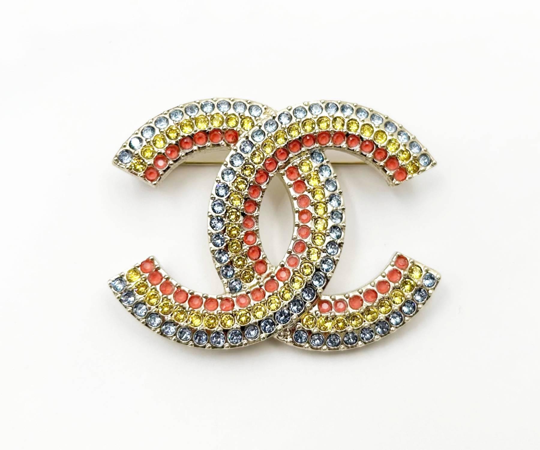 Chanel Brand New Gold CC Rainbow Blue Yellow Pink Brooch 

* Marked 23
* Made in France
* Comes with the original box, pouch, tag, booklet, ribbon and camellia
* Brand new

- It is approximately 1.6