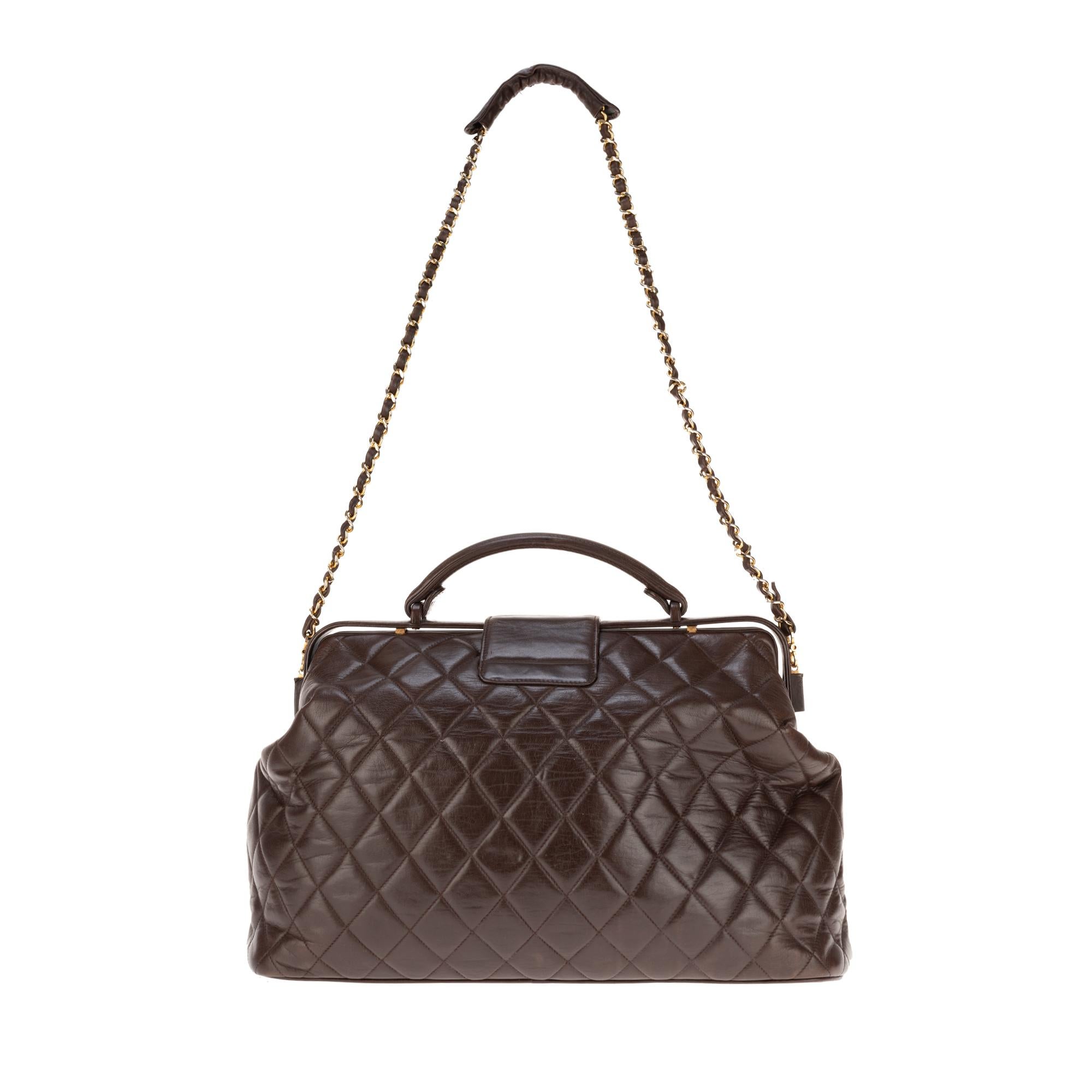 Chanel briefcase style bag in brown quilted lambskin leather, carried by central handle in brown leather or shoulder-worn with gold chain handle intertwined with brown lambskin leather.
Closure by small flap sigled gold CC and turnstile.
Opening by