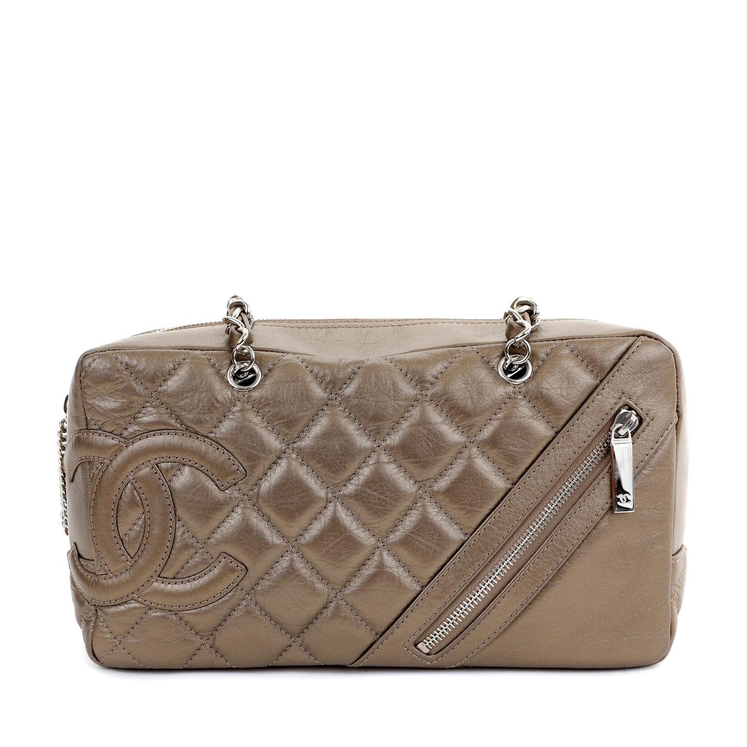 This authentic Chanel Bronze Lambskin Cambon Camera Bag is in excellent condition.  Intentionally distressed metallic bronze lambskin is quilted in signature Chanel diamond pattern.  Large interlocking CC is tonally stitched off to the side with a