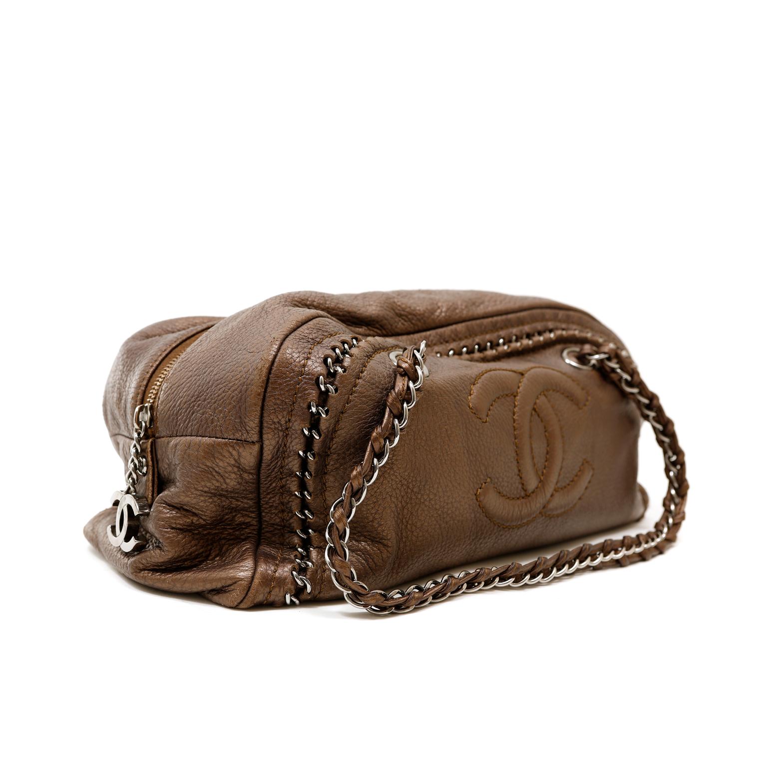 This authentic Chanel Bronze Luxe Ligne Bowler Bag is in excellent condition from the 2006 collection.  Perfectly scaled for every day enjoyment, the neutral color and exposed chain details make this Chanel a chic companion.
Subtle metallic bronzy