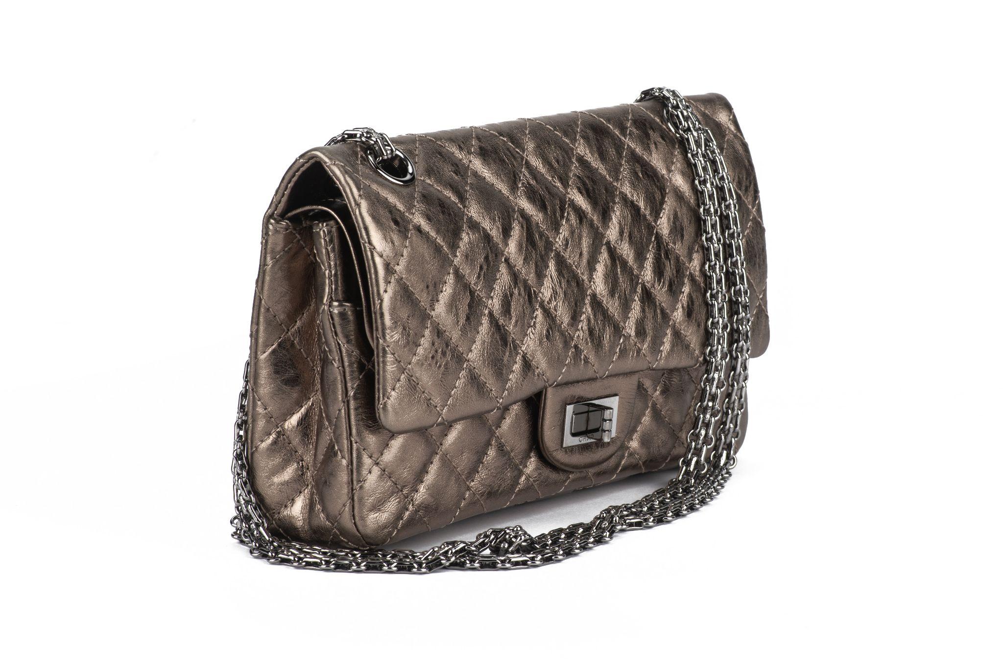 The Chanel Metallic Aged Calfskin Quilted 2.55 Reissue Flap Bag. This is a chic classic reissue is crafted of quilted calfskin leather in gold. The shoulder bag has ruthenium tightly linked shoulder chains and a ruthenium Chanel mademoiselle turn