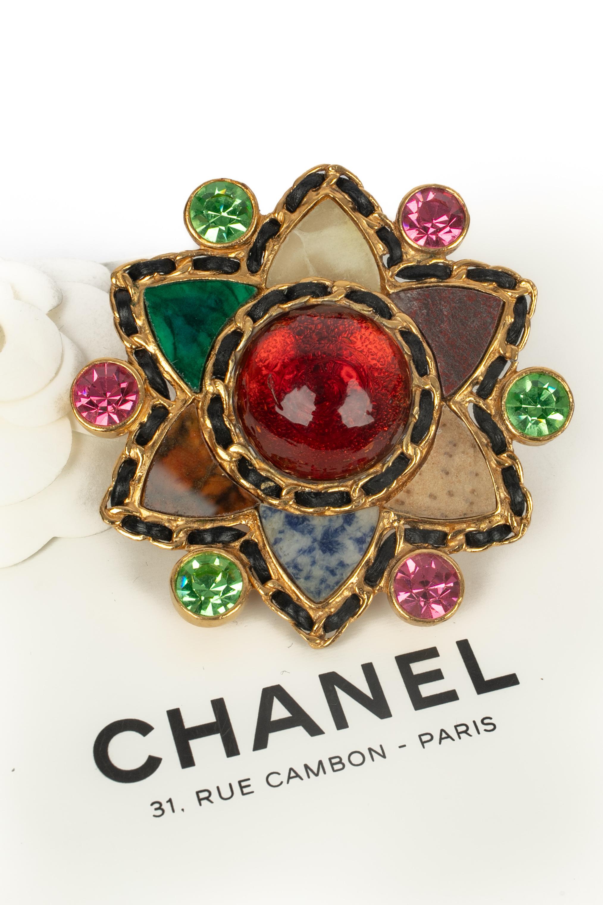 CHANEL - (Fabricado en Francia) Broche de metal dorado entrelazado con cuero negro, decorado con piedras semipreciosas y strass multicolor. Una colección de los años 90.

Estado:
Muy buen estado

Dimensiones:
Altura: 8 cm

SKU:BRB17