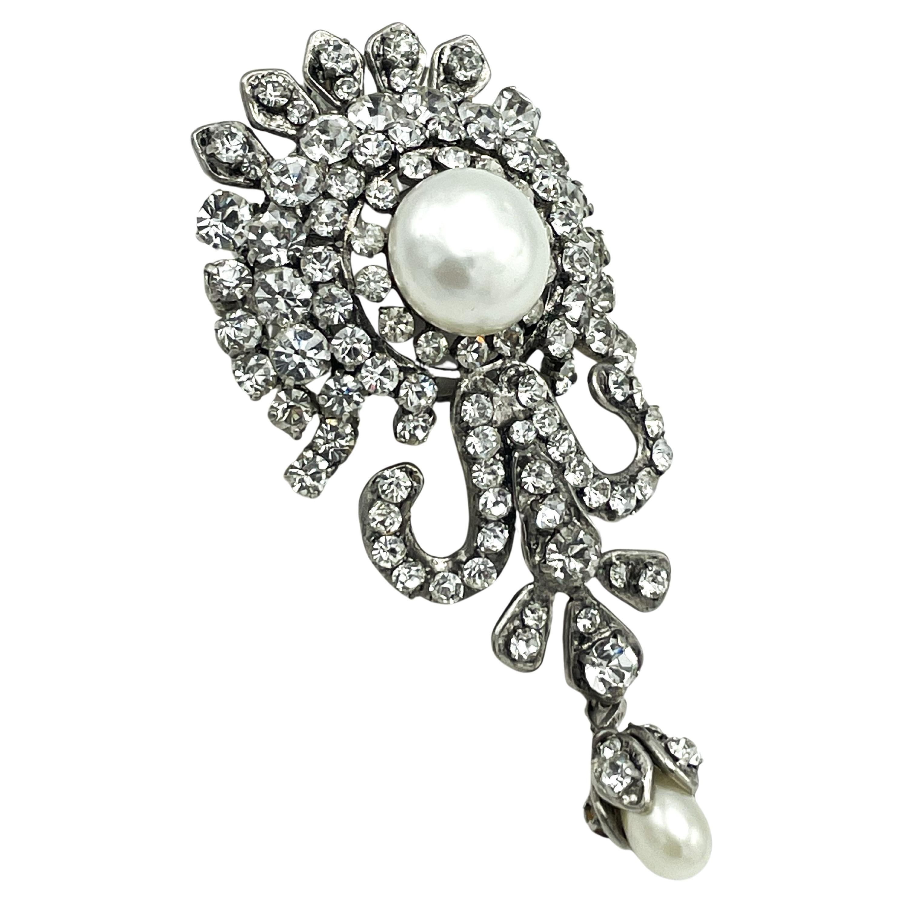 Acerca de
Elegantísimo broche Chanel (Made in France) de metal rodiado  y engastada con muchos brillantes y 2 cuentas artesanales.  Se adjunta una pequeña gota de perla móvil.
Medición: 
Longitud 9 cm (3,5 pulgadas) 
Anchura    4 cm  (1,55 pulgadas)