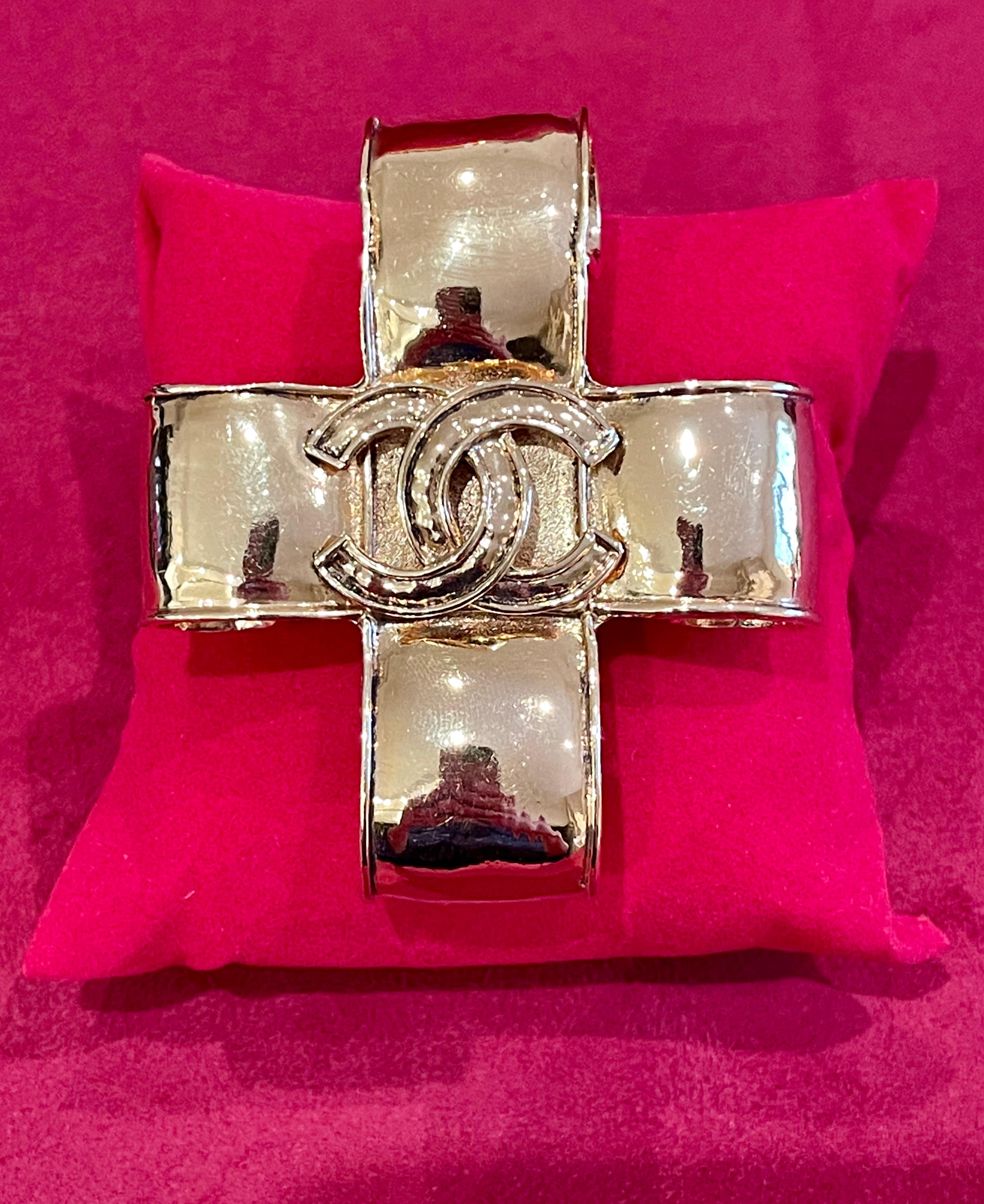 Superb Chanel brooch in gold plated with 94P scrolls forming a cross. Very beautiful model, of good size with in its center the famous 