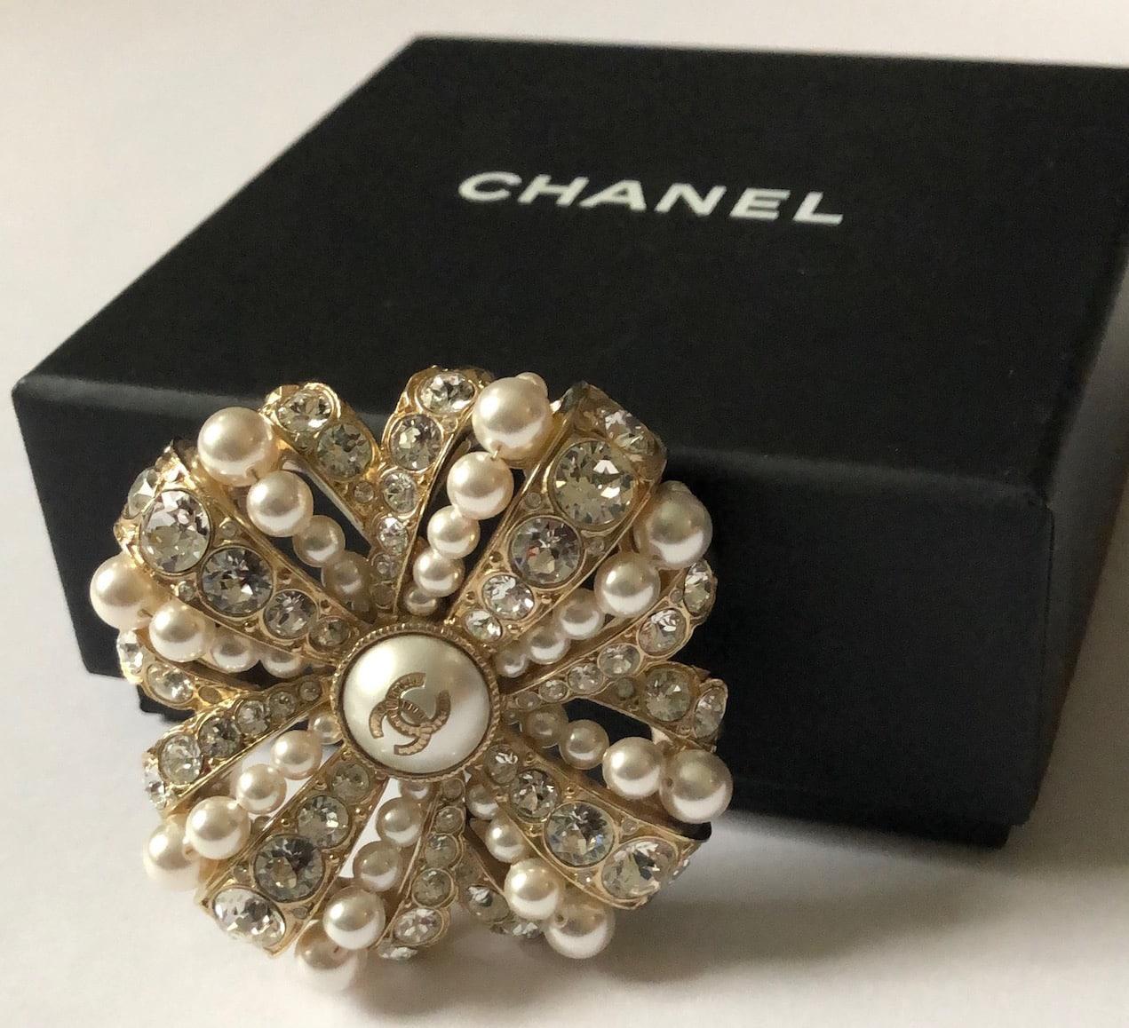 CHANEL Brosche CC Logo Perle & Kristalle Pin W/Box
Eine atemberaubende Chanel Brosche Herbst 2020 Kollektion, in Gold Metall mit Kristallen und cremefarbenen faux Perlen veredelt. Diese Brosche ist von einer militärischen Medaille inspiriert. Es ist