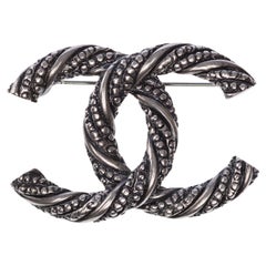 CHANEL Broche CC metal plateado