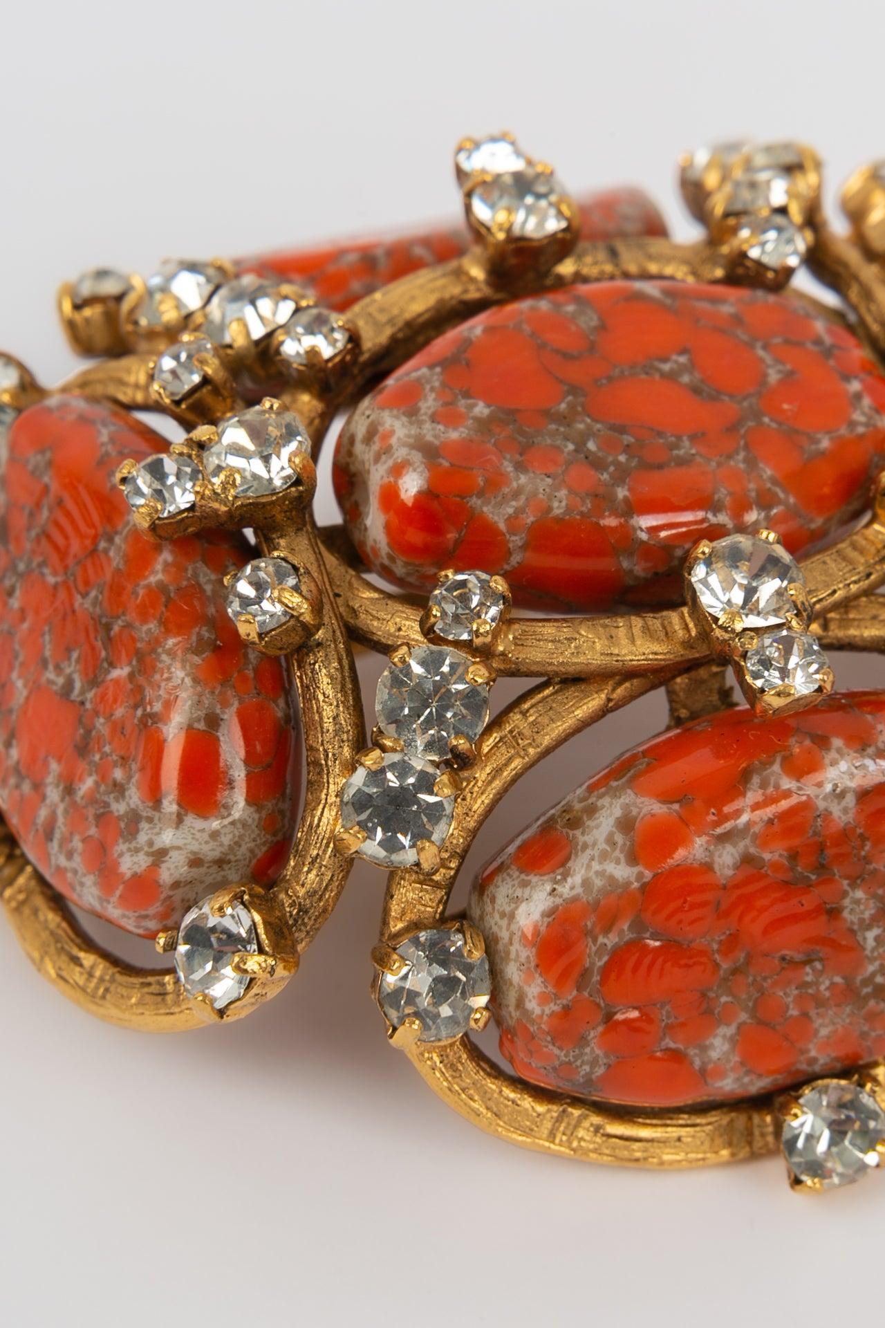 Chanel- Brooch in gilded metal, orange glass paste and Swarovski strass. 
Collection Spring/Summer 1994

Additional information:

Dimensions: 
6 W x 7 H cm

Condition: Very good condition
Seller Ref number: BRB42