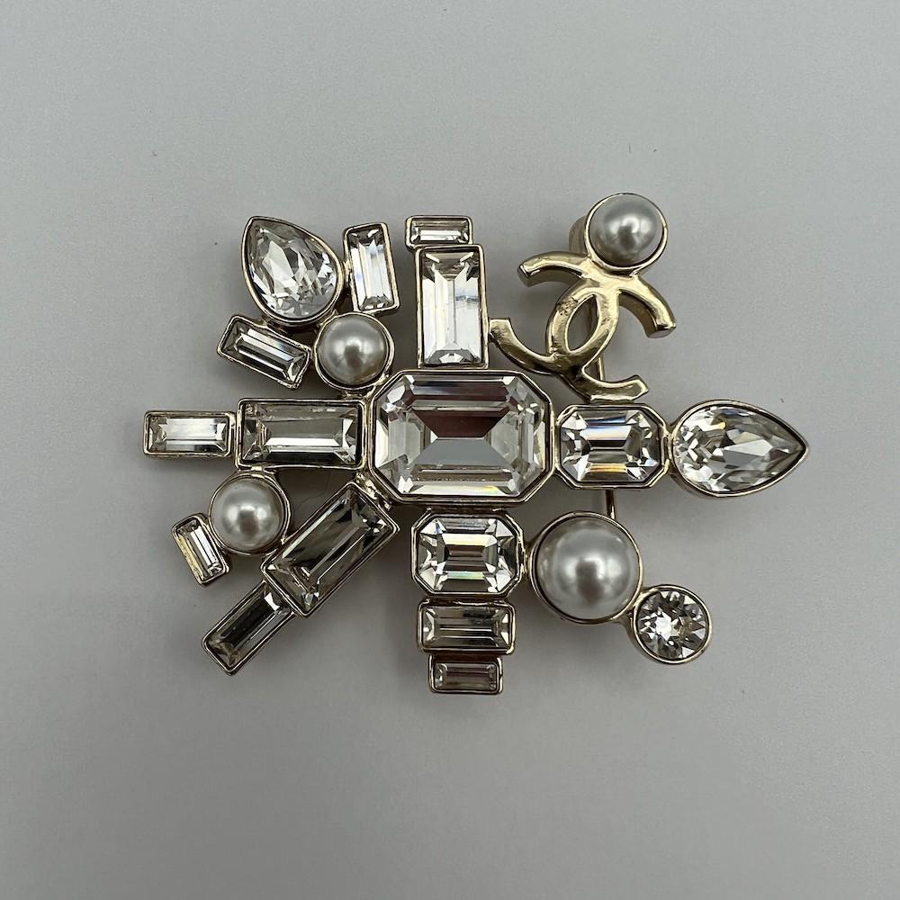 Beautiful Chanel brooch with strass and pearls

Condition: very good (micro-scratches on the back)
Made in France
Color: pale gold
Material: gold metal
Dimensions: 4 x 5,7 cm
Stamp: yes
Year: 2022