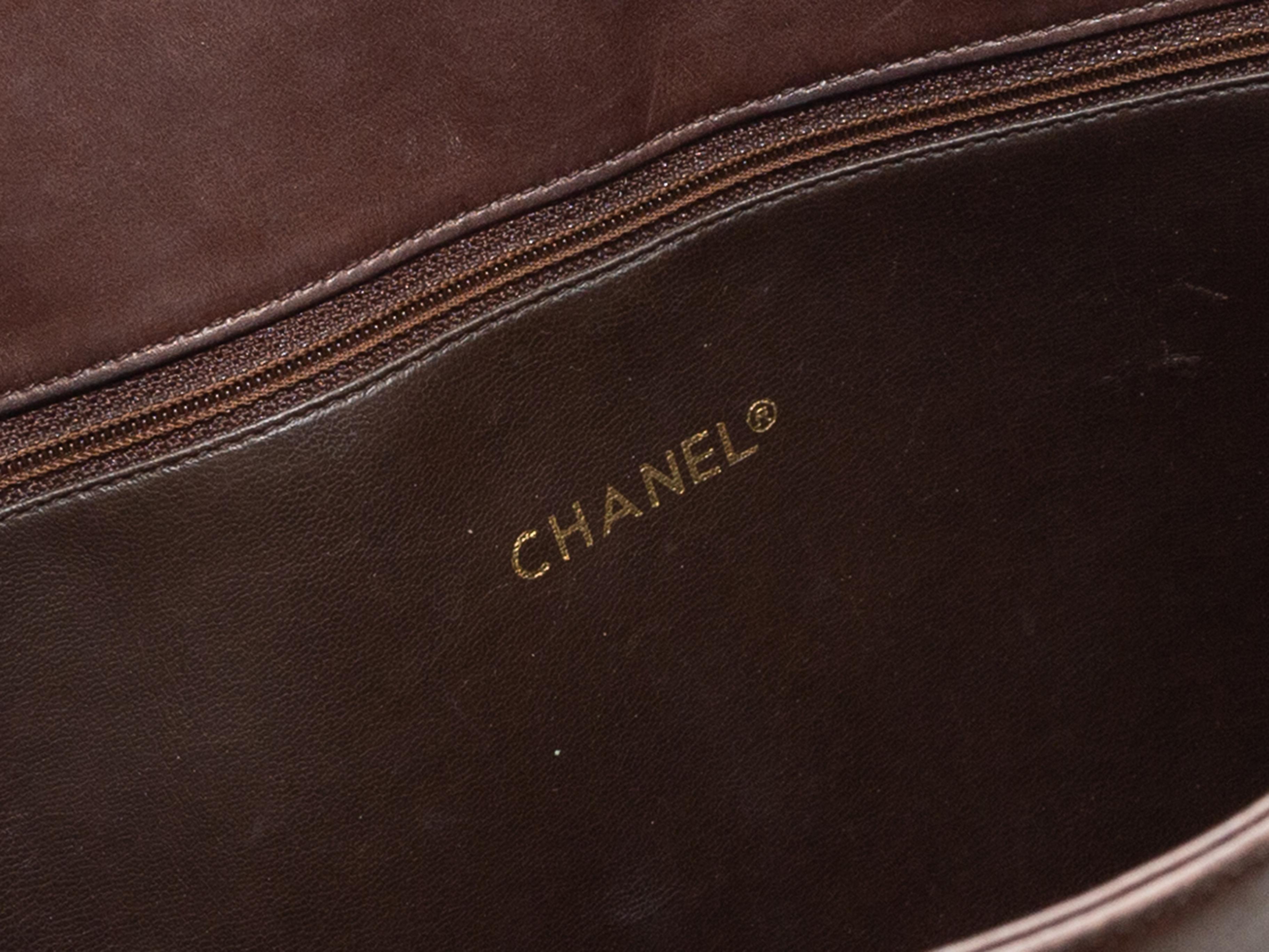 Product details: Vintage brown leather tote bag by Chanel. Circa late 1980s. Gold-tone hardware. Interior zip pocket. Dual chain-link and leather shoulder straps. 14