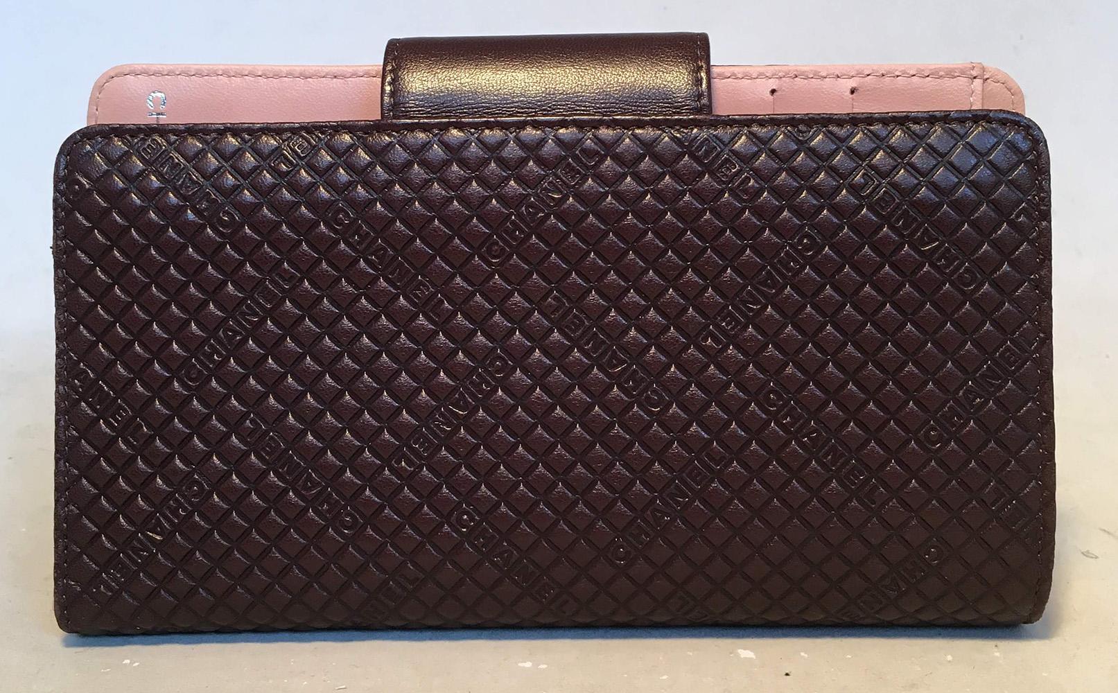 Chanel Brown and Pink Leather Embossed Wallet in excellent condition. Brown leather embossed with a unique square pattern and chanel throughout trimmed with pink leather and CC logo along snap strap closure. Pink leather interior with one coin