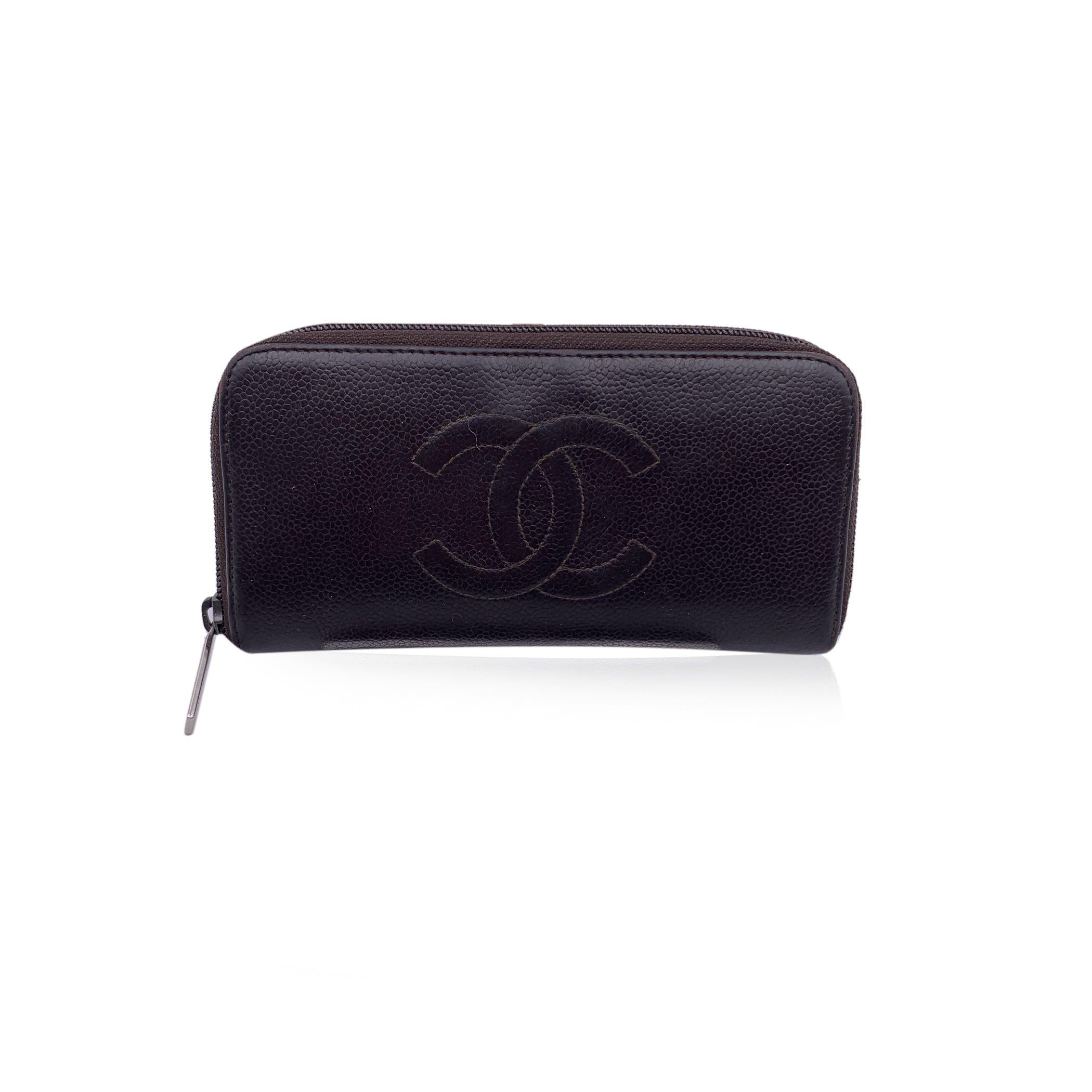 Classic Chanel long zip wallet, crafted of brown caviar leather with front CC logo. Period/Era: 2006/2008. Silver metal hardware. Rear zip pocket (the zipper pull has been replaced with an unsigned one). Upper zipper closure. Inside it has 8 credit