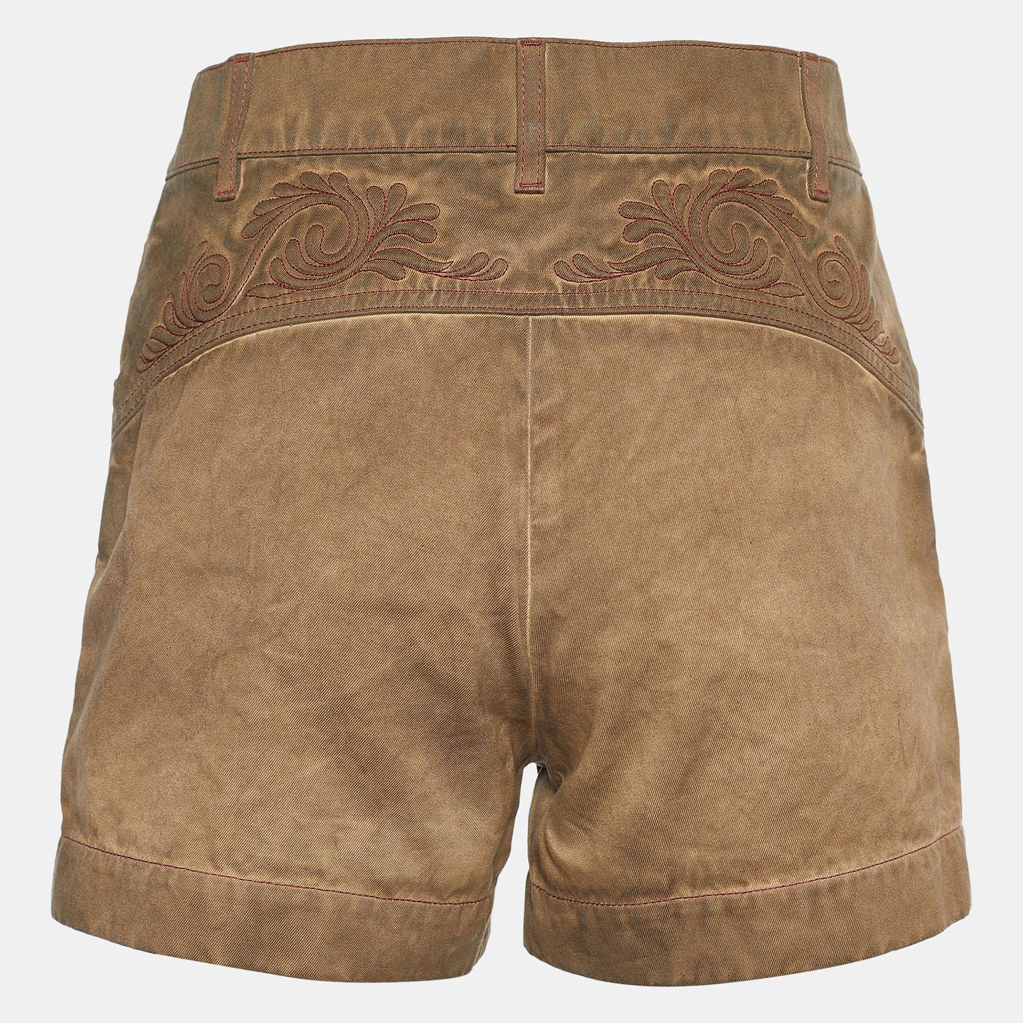 These shorts from the House of Chanel are a closet essential. They are tailored from brown cotton twill fabric and showcase embroidery and overdyed detailing. They feature a buttoned closure and two external pockets. These Chanel shorts are great