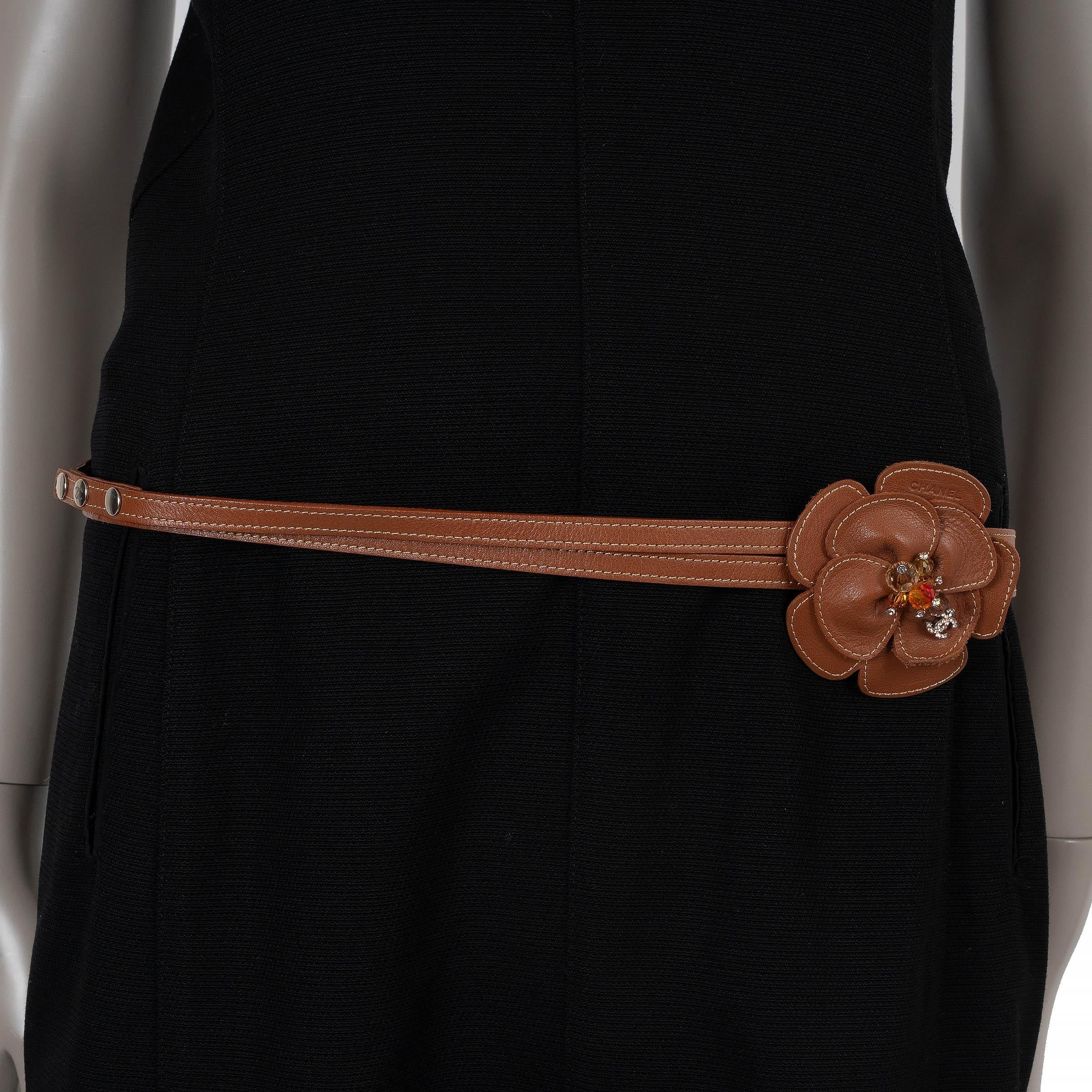Este cinturón doble Chanel 100% auténtico de piel marrón presenta costuras amarillas en contraste y una silueta delicada y estrecha. El detalle de la flor de camelia está adornado con cuentas de cristal color ámbar y una CC incrustada de cristal,