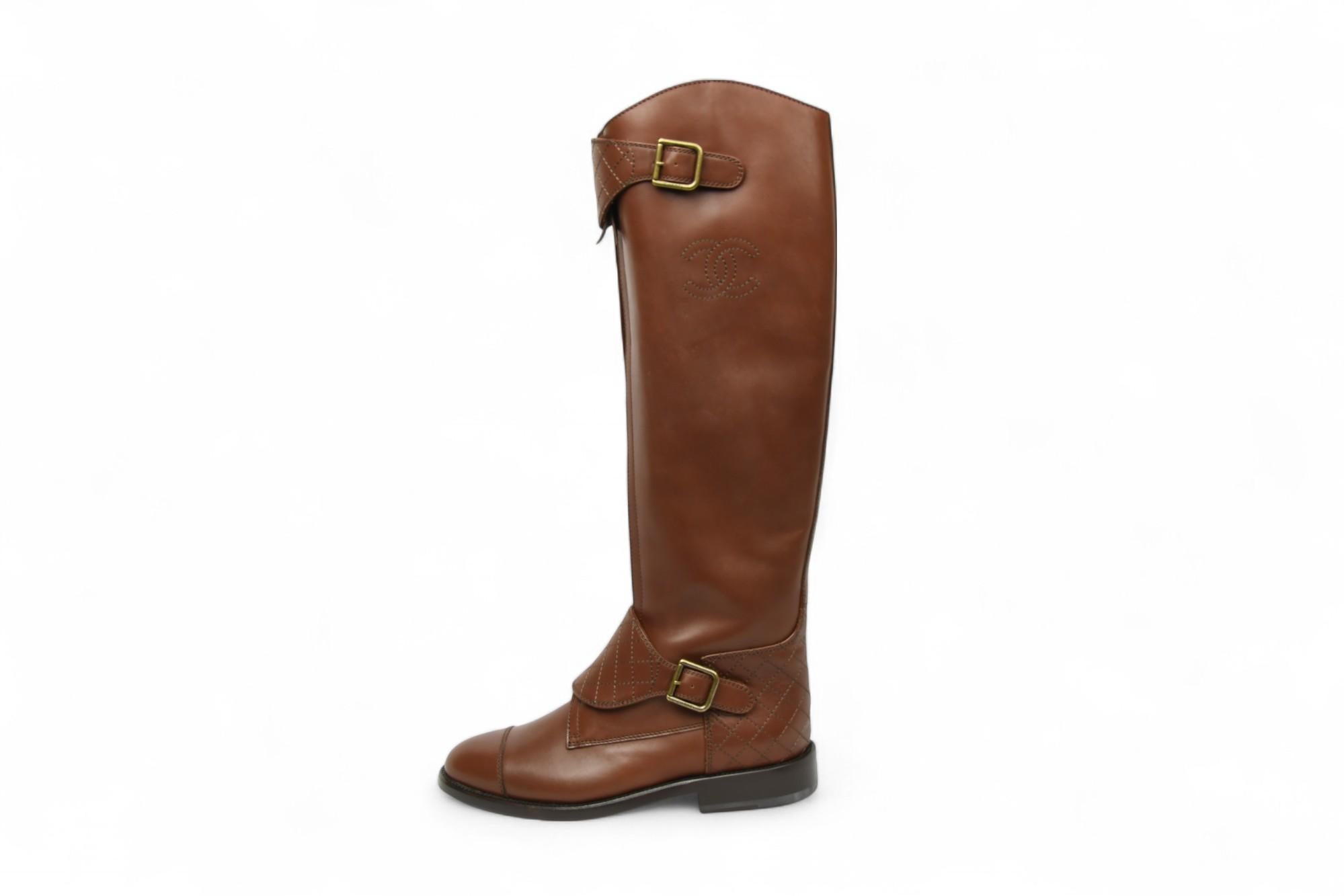 Dieser kniehohe Stiefel von Chanel aus glattem braunem Kalbsleder ist ein echter Hingucker, der vom Reitsport inspiriert ist. Mit gesteppten Ledereinsätzen, goldfarbenen Schnallen und aufgenähten CC-Logos am Schaft verbindet dieses Paar