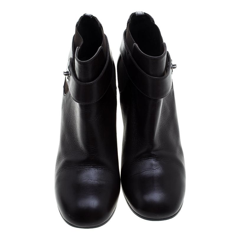 A blend of style and bold simplicity, these ankle boots from Chanel will sweetly complement your casual as well as evening ensemble. Crafted with black leather, the boots are characterised by the CC twist lock closure detailed on the straps. They