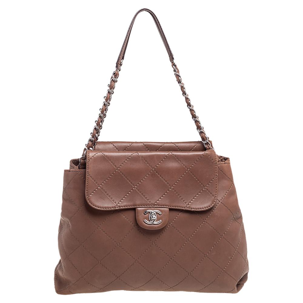 This beautifully stitched bag in leather is by Chanel. With capacious satin-lined compartments, it will house more than your essentials. Boasting two shoulder handles, the signature diamond quilt, and a seamless finish, this tote offers style and