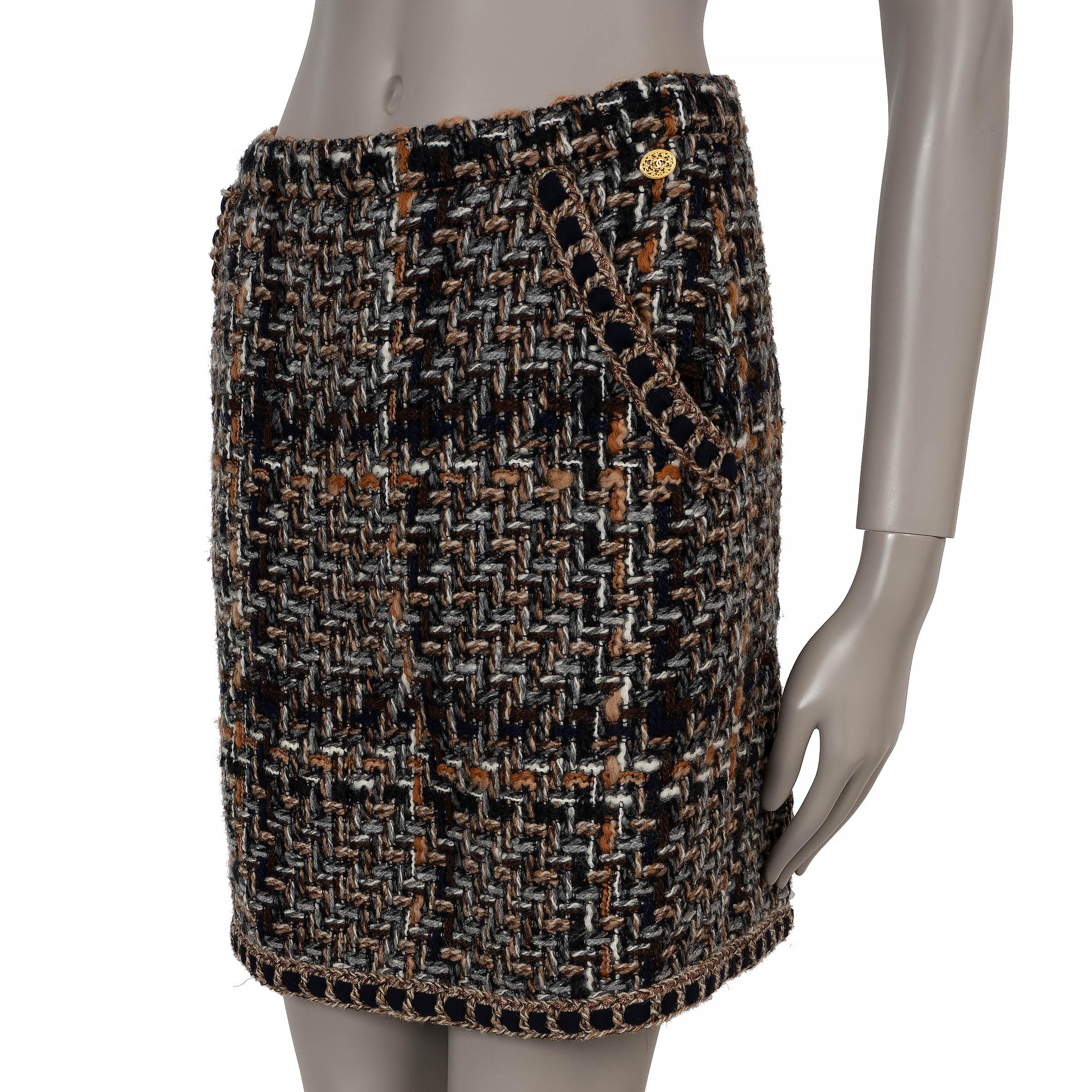 This 100% authentic Chanel skirt in brown, navy blue, beige, and grey tweed wool (65%), cotton (12%), acrylic (12%), angora (4%), mohair (3%), silk (2%), and nylon (2%) is a timeless statement of elegance. Featuring a high-waisted, straight-cut mini