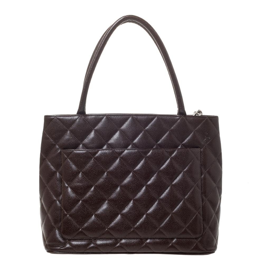 This incomparable Medallion tote from Chanel is handy and gorgeous. It is made from quilted Caviar leather and designed with the CC logo on the front, two handles and a CC logo zipper pull which leads to a well-sized leather interior. You will want
