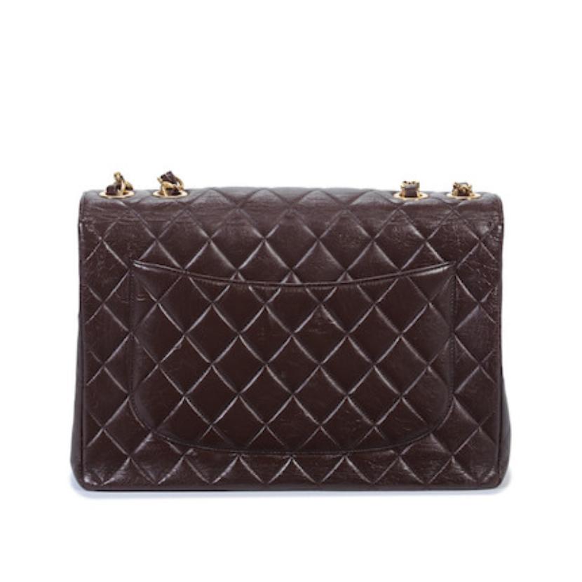 Crafted from soft lambskin leather, this Brown Quilted Lambskin Jumbo Flap from Chanel 1997-1999 features a single flap design with a white leather interior and 24k gold-plated hardware. Finished off with the signature Chanel quilting and 'CC'