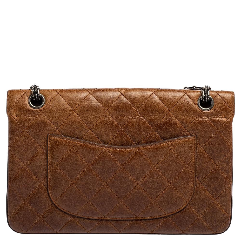 This 2.55 Reissue Classic 226 Flap bag from the House of Chanel is a beauty to behold. It is made from brown quilted leather on the exterior and comes with a logo embellishment on the front. It has Dark Ruthenium hardware, a leather-lined interior,