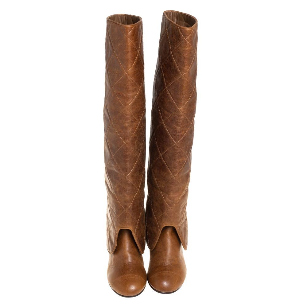 These over-the-knee boots from Chanel epitomize effortless style. They come crafted from brown leather and feature round toes. They have been styled with a fold-over flap that carries the signature quilted pattern and elevated on 6.5 cm block heels.