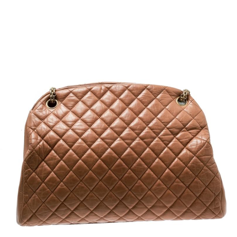 Spacious and captivating, this Just Mademoiselle Bowler bag is from Chanel. It has been crafted from brown leather and features the iconic quilted pattern. It is equipped with two chain handles and a well-sized fabric interior to keep your