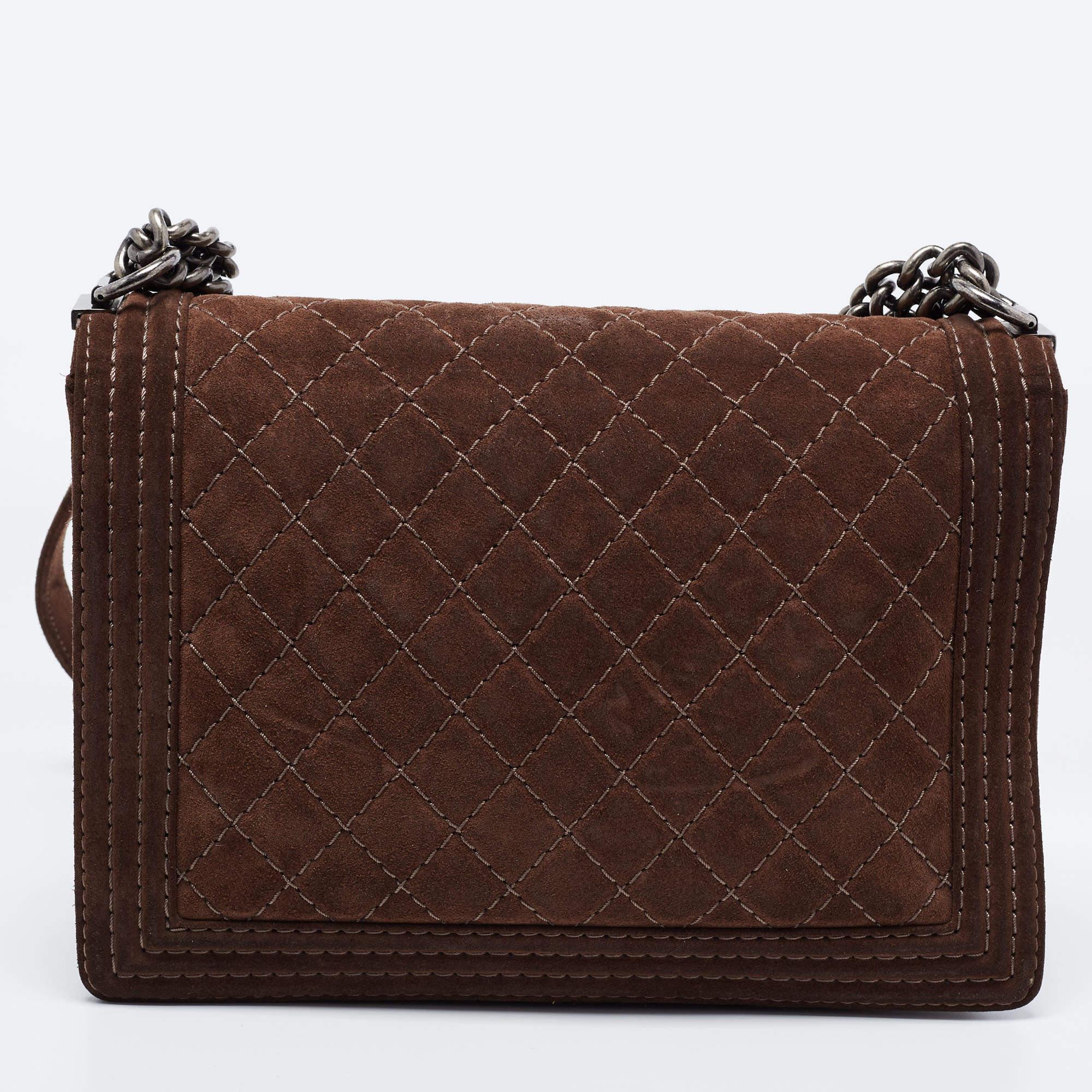 Introduced as a part of the Chanel Fall/Winter collection of 2011, the Boy bag embodies an alluring appeal and is complemented with exquisite details. This brown creation is meticulously crafted from quilted suede with side panelling and features a