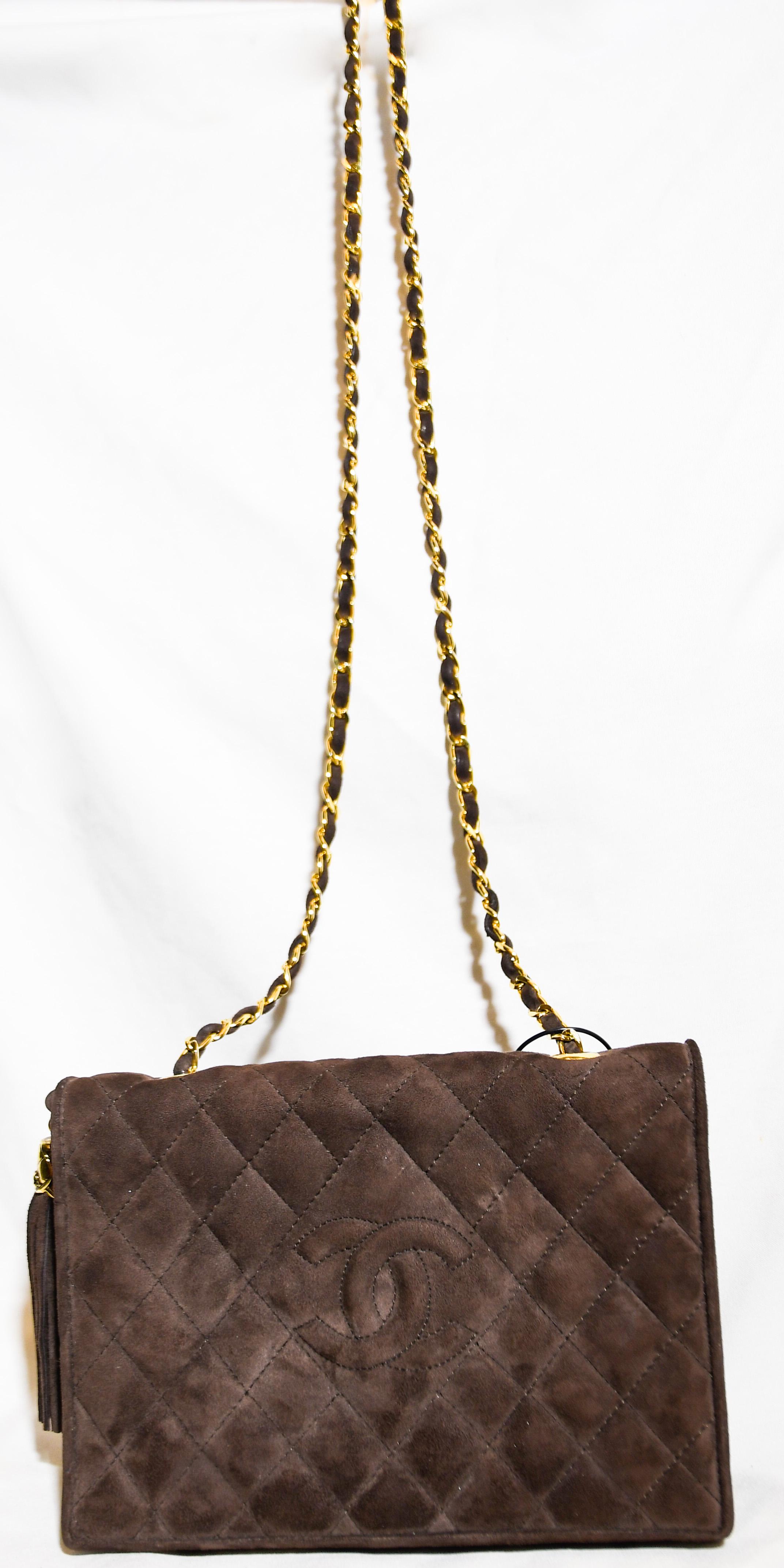 Chanel brown suede 1990's side fringe tassel shoulder bag crafted from brown lambskin and leather and contains a gold tone chain and leather strap.  Bag feature the brand's iconic diamond quilting.  This single flap bag includes a magnetic snap
