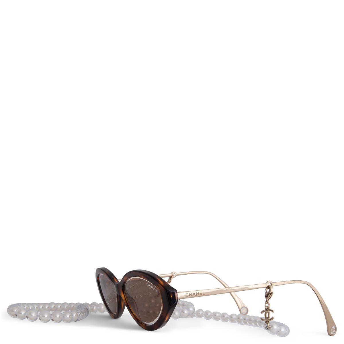 100% authentic Chanel oval  brown and camel tortoise sunglasses in acetate and brown lenses. They come with a removable white and clear pearl chain with metal CC logo. Have been worn and are in excellent condition. Come with pouch.