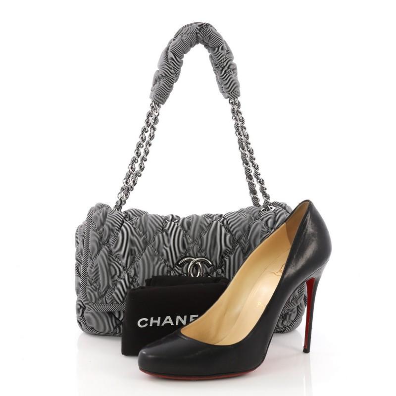 This Chanel Bubble Flap Bag Quilted Nylon Medium, crafted in black and gray striped quilted nylon, features a woven-in nylon chain link strap, CC logo at the front and silver-tone hardware. Its flap opens to a black fabric interior with side zip