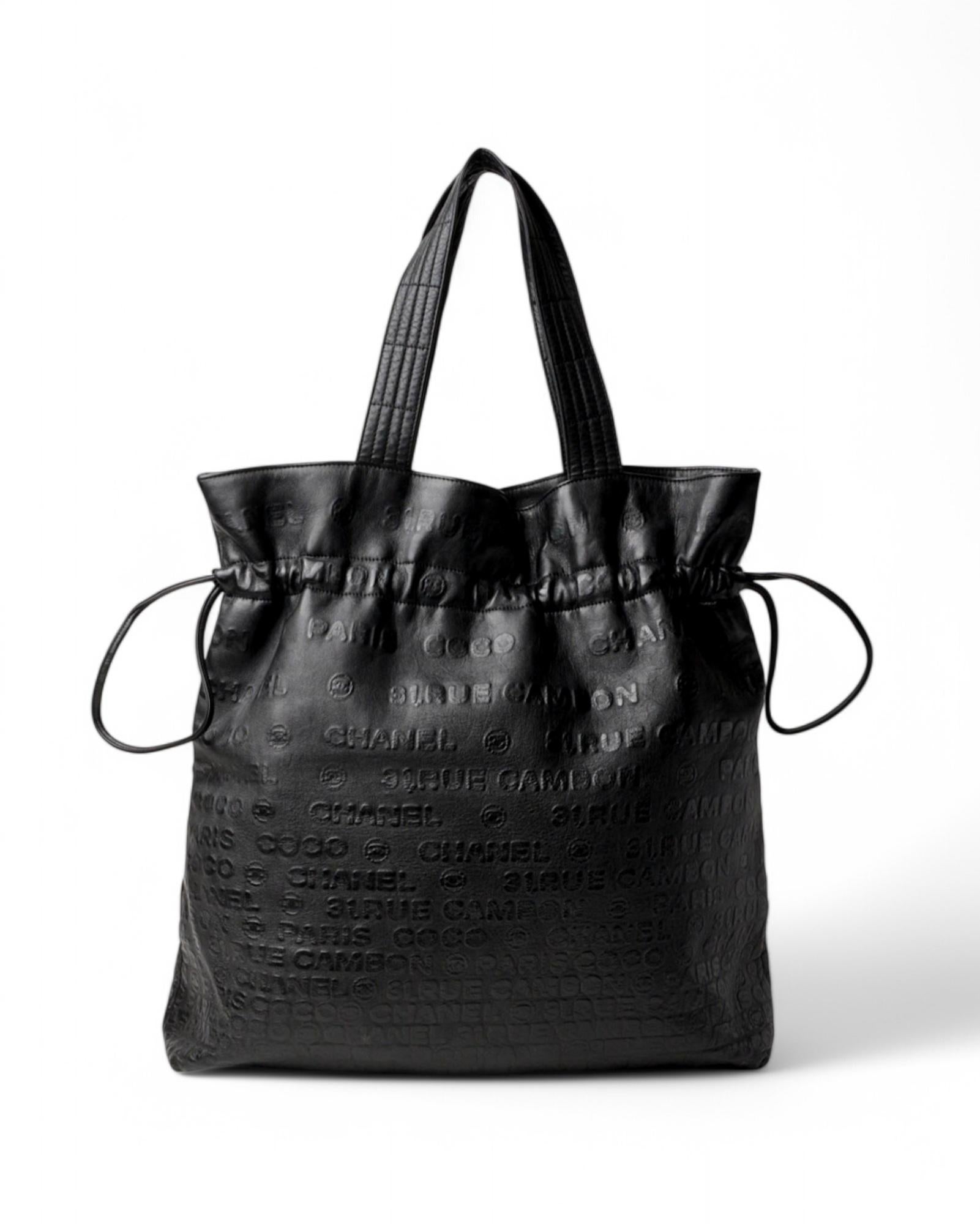 Chanel signature bag, Bucket model, made of soft black leather with the brand's logo embossed across the surface and silver hardware details. Featuring a magnetic drawstring button top closure, the interior is lined in beige fabric and has