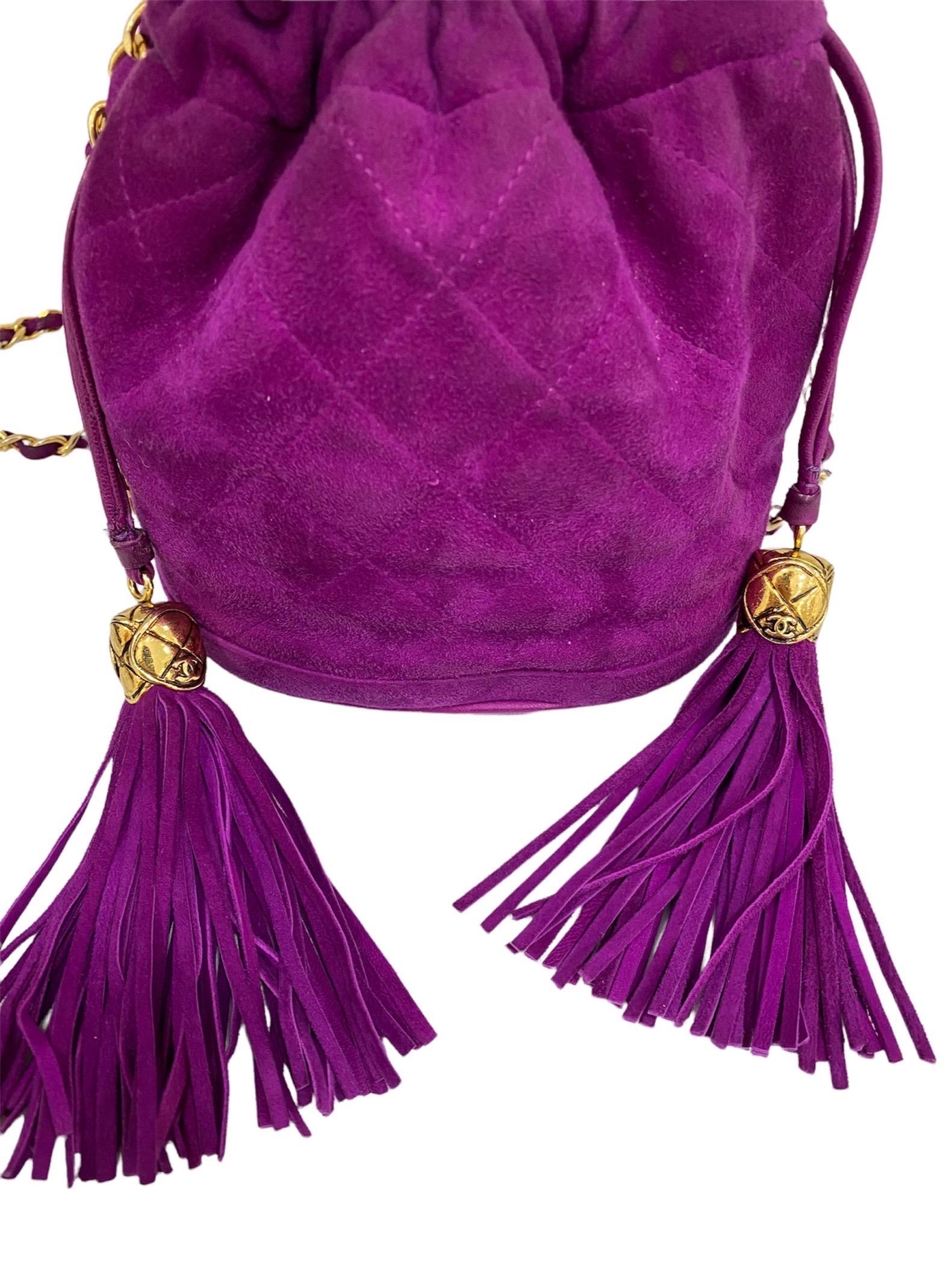 Bucket bag signed Chanel, made of purple suede with golden hardware.

Equipped with a lace closure, internally lined in black leather, roomy for the essentials.

Equipped with a woven leather and chain shoulder strap and an inside pocket with zip
