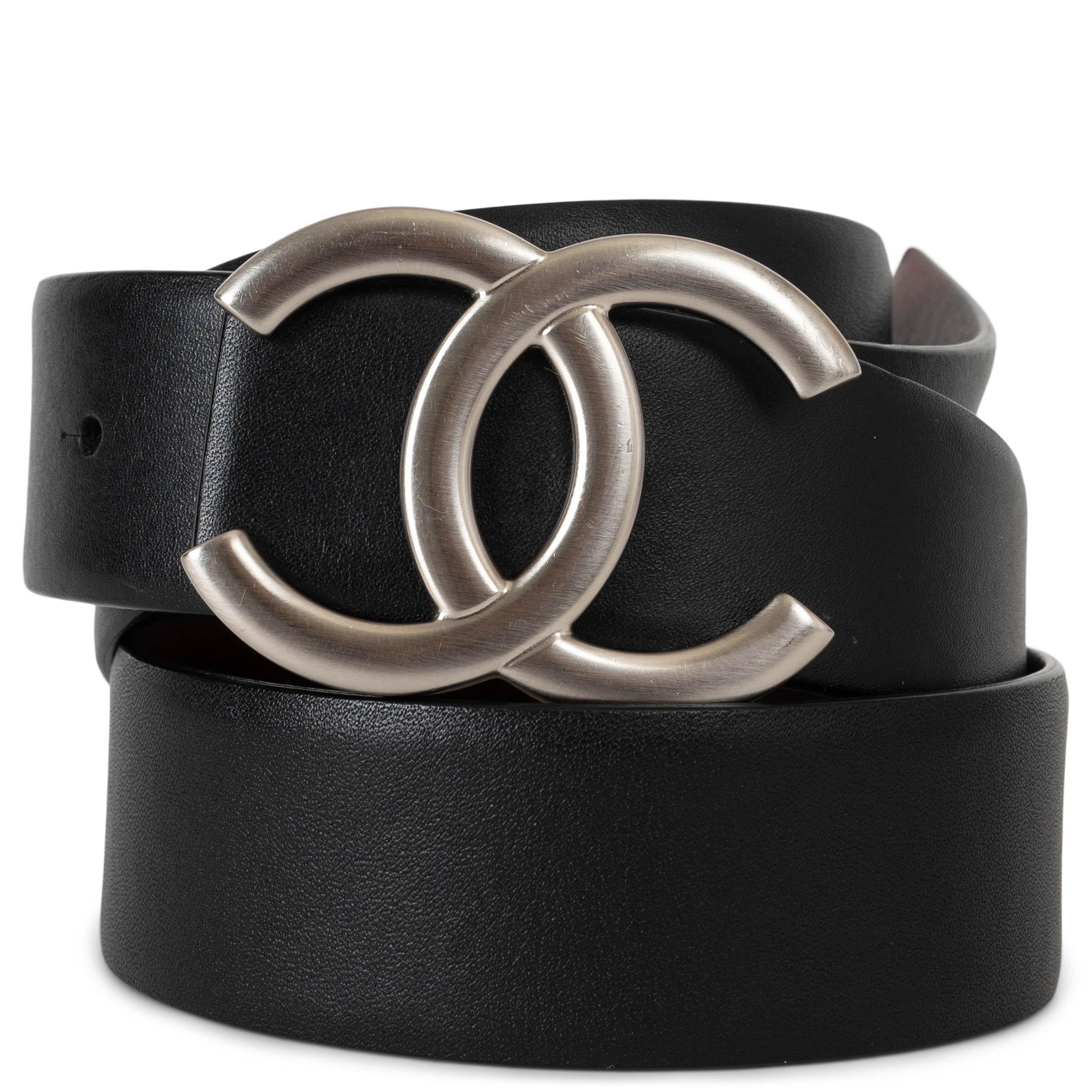 This 100% authentic Chanel reversible belt in black and burgundy leather offers versatile elegance. Featuring a matte silver-tone CC buckle, this timeless accessory allows for effortless styling, seamlessly transitioning between classic black and