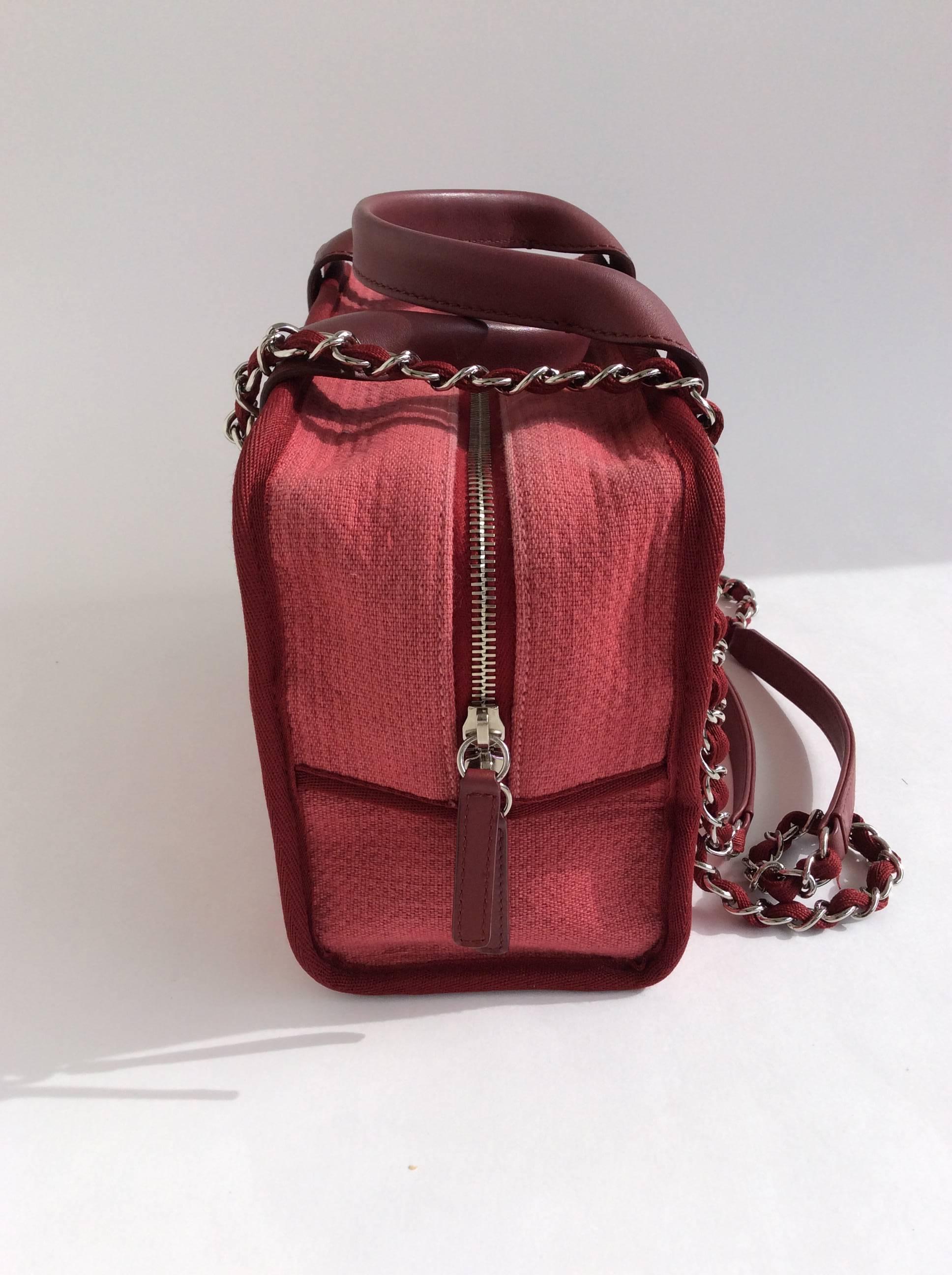 Chanel Burgundy canvas handbag with signature chain straps and leather handles. Zip closure with interior zippered pocket. Dust bag and authenticity card included. 

Dimensions: 10.5x7x4.5 inches

Strap drop: 14 inches

