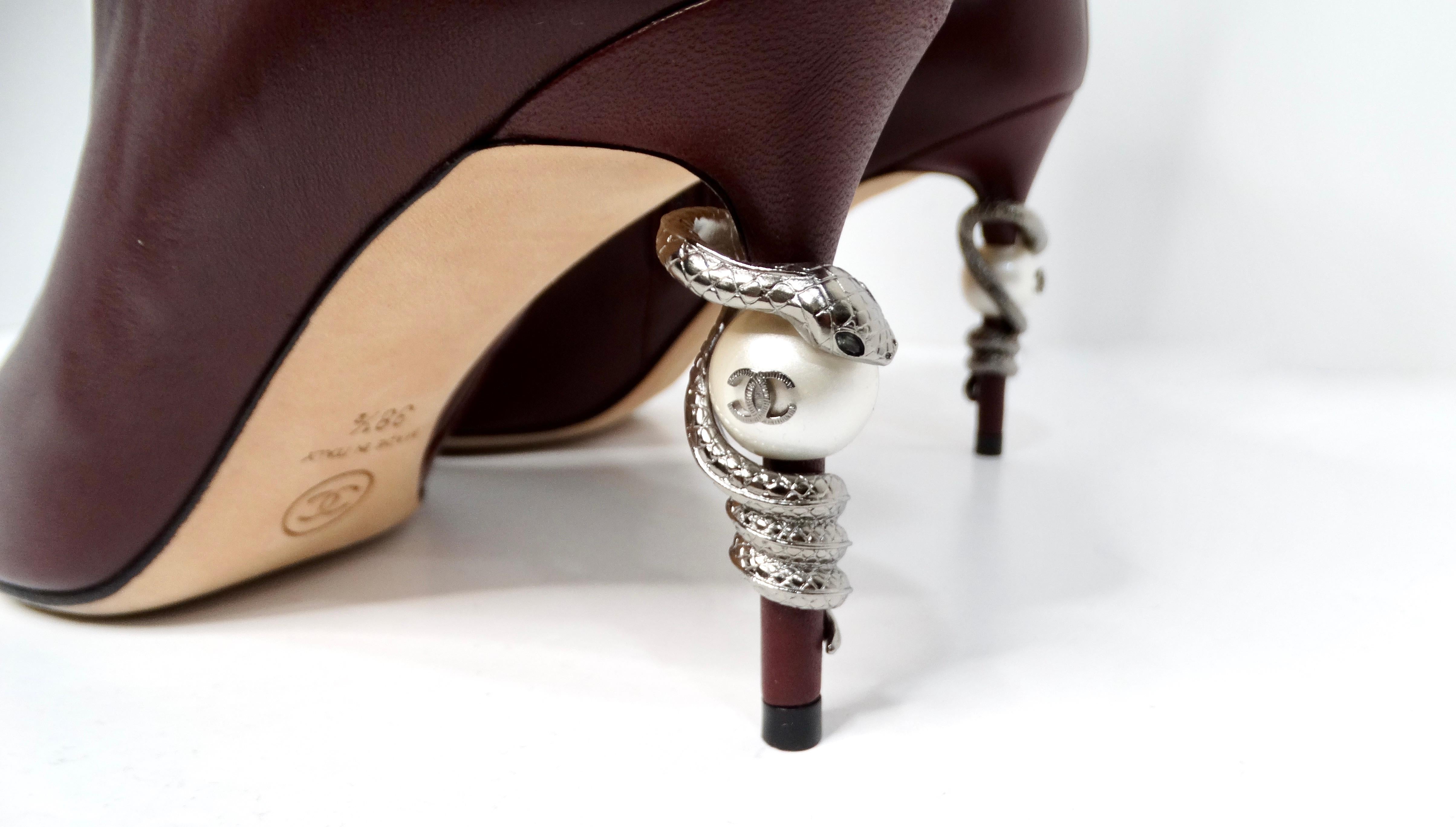 The Chanel Burgundy Lambskin Leather Heel Boots with Pearl & Snake Motif are a stunning blend of elegance and daring design, embodying the luxury synonymous with the Chanel name. Crafted from sumptuous lambskin leather in a rich Bordeaux hue, these