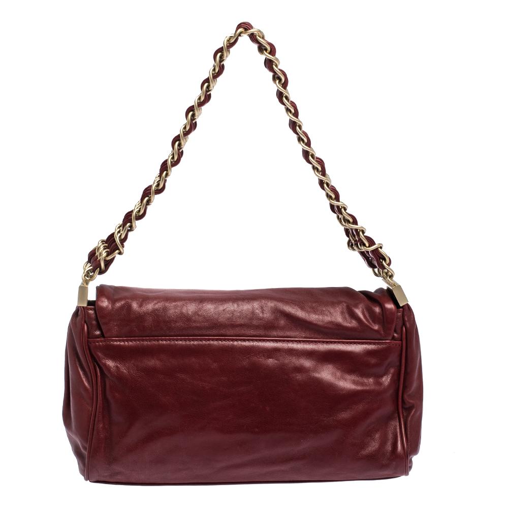 A stylish flap bag is an everyday staple for all fashionistas! This bag from the house of Chanel is crafted from leather and covered in a burgundy shade with CC logo on the front flap. The piece is equipped with a well-sized satin interior and hefty